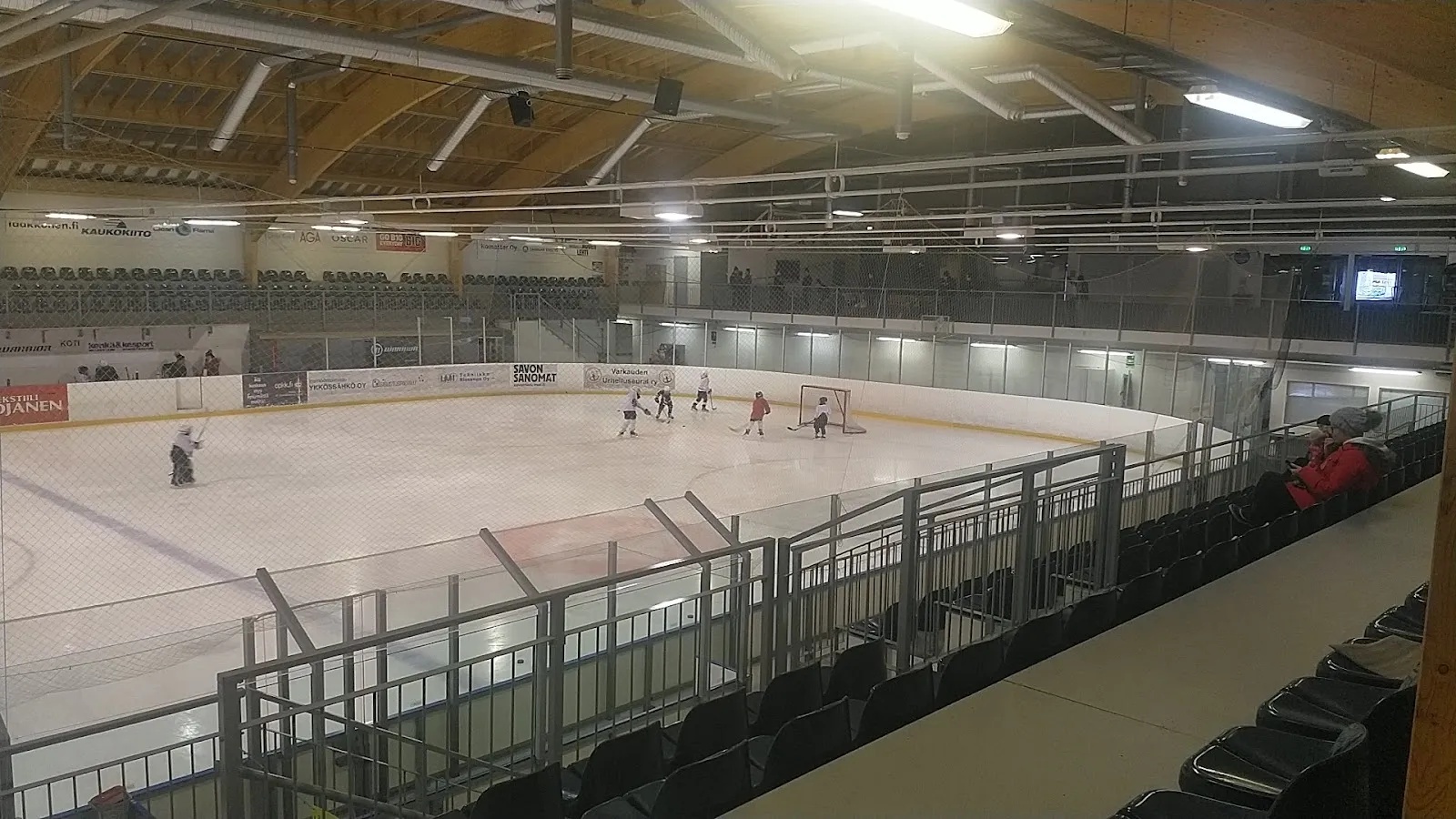 Players at a distance on the ice of the main hall at the Kämäri ice sports centre in Varkaus, seen from the stands — Kämärin jääurheilukeskus