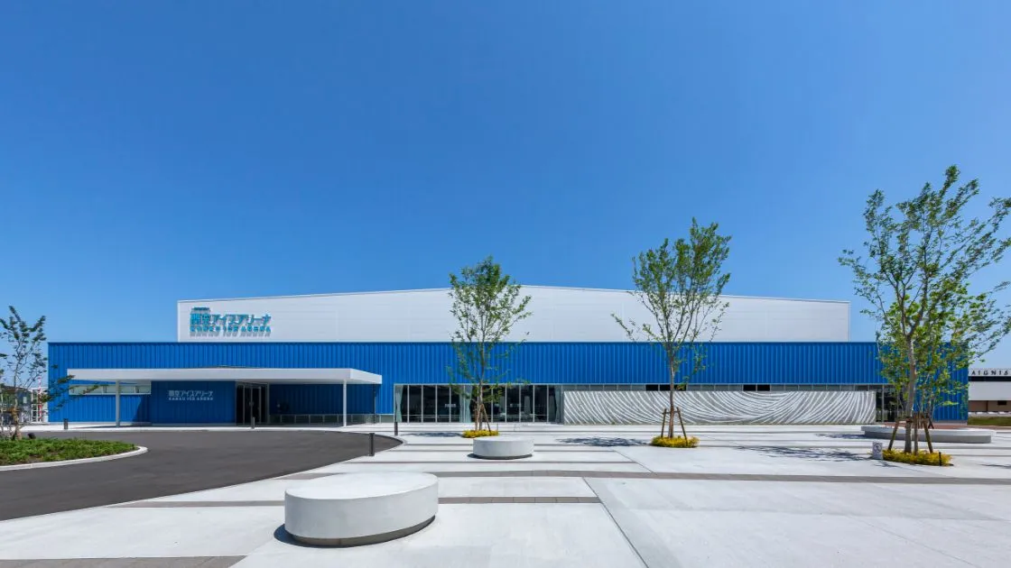The blue-and-white front of the Kanku Ice Arena in Rinku Town with its name on the roof wall — Kanku Ice Arena