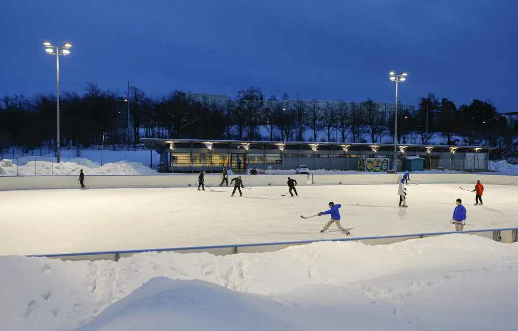People in a rink playing ice hockey at Käpylä. — Käpylän liikuntapuisto – tekojääkaukalo