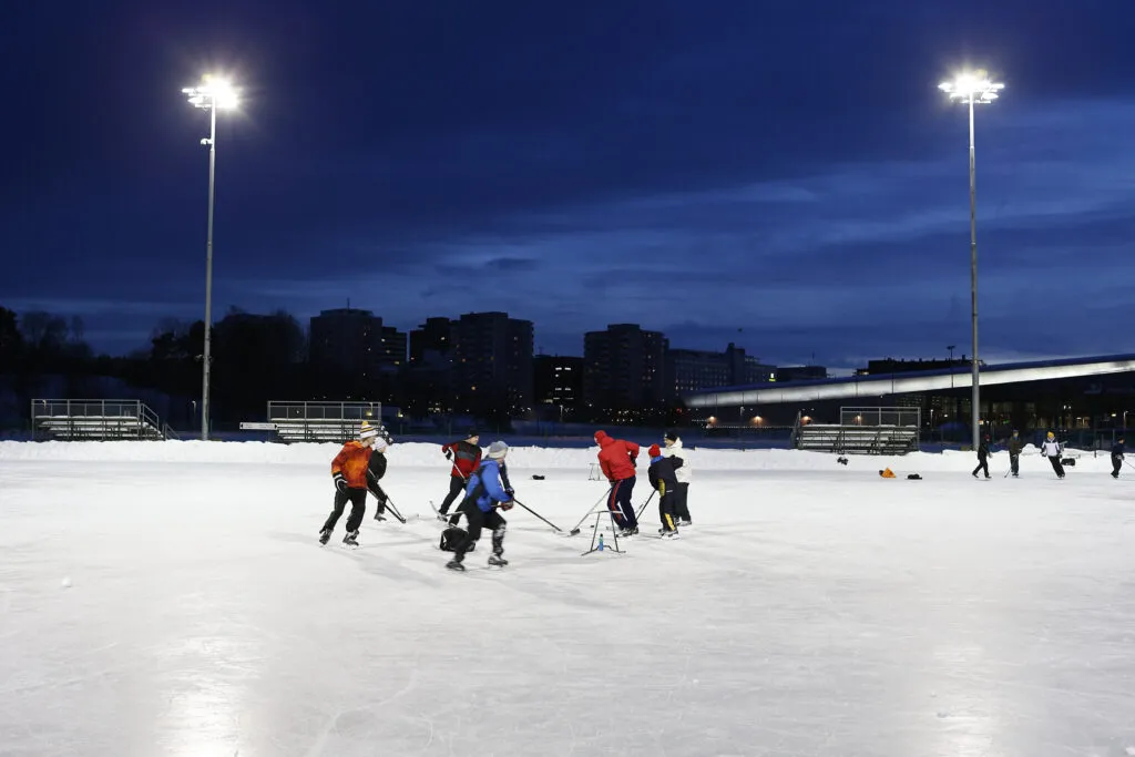 People playing ice hockey on the artificial ice rink at Käpylä. — Käpylän liikuntapuisto – tekojääkenttä