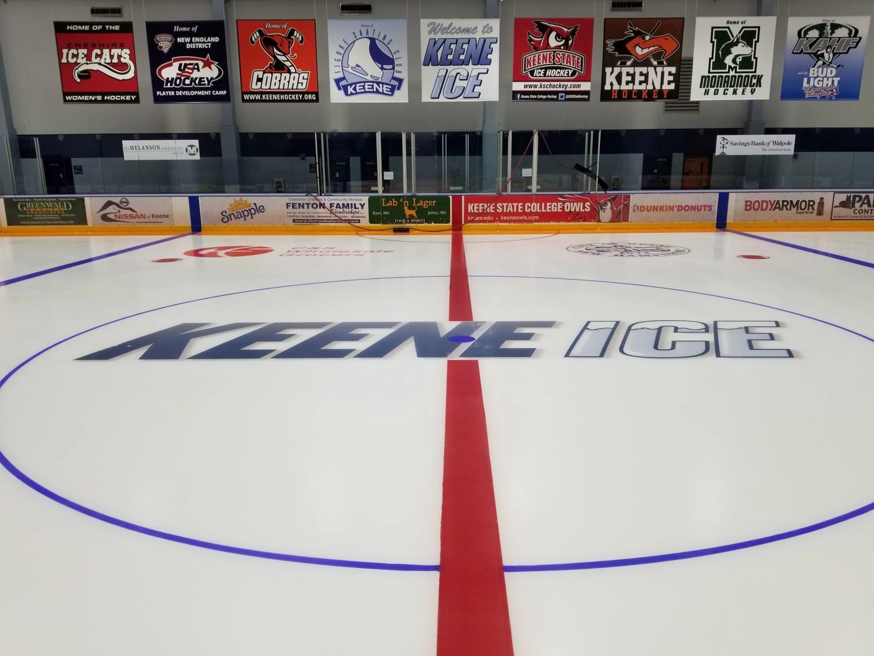 Center ice at Keene ICE, with the rink’s name and local team banners. — Keene Ice