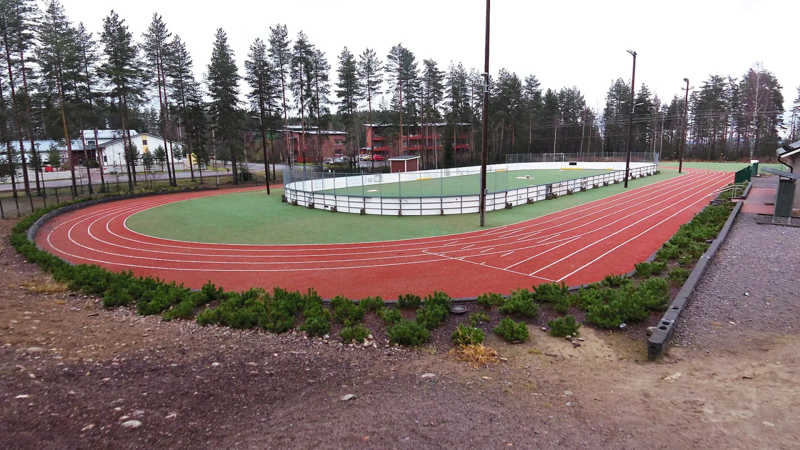 The boarded field inside the running track at Keljonkangas sports park, seen in summer. — Keljonkankaan liikuntapuiston luonnonjäät