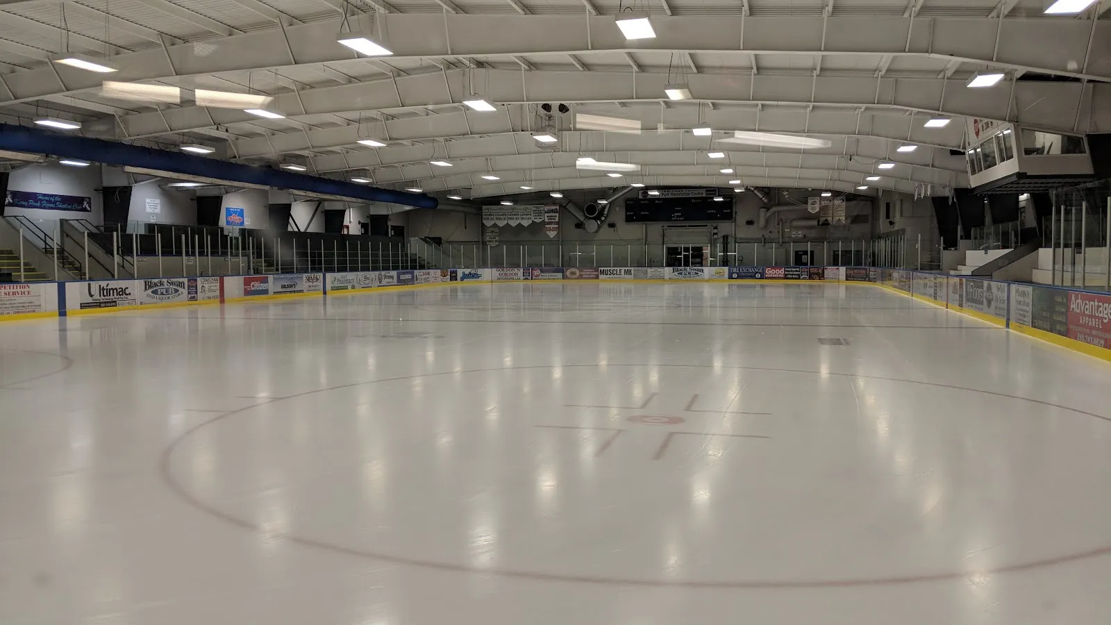 The empty ice sheet at Kerry Park Recreation Centre with its centre circle, the boards and the arched roof overhead. — Kerry Park Recreation Centre