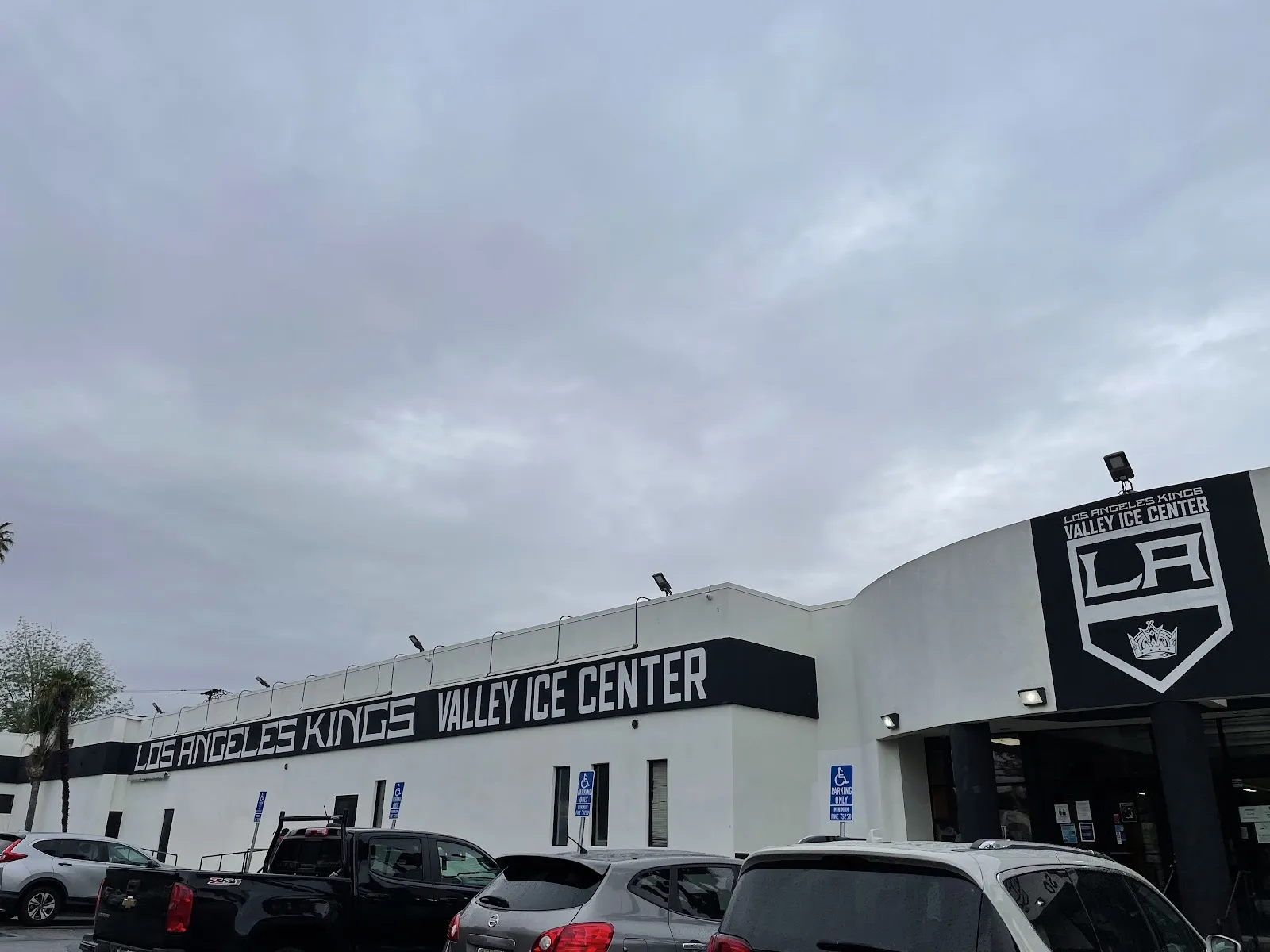 The LA Kings Valley Ice Center, a long white building with the rink's name in a black band and the Kings crest above the entrance — LA Kings Valley Ice Center