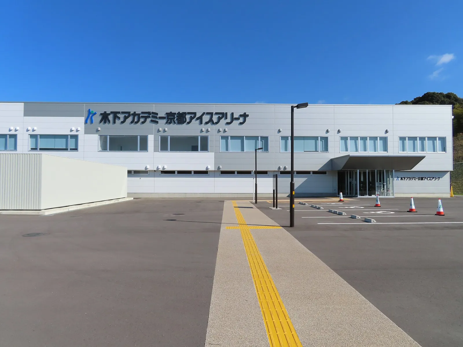 The grey two-storey building of the Kinoshita Academy Kyoto Ice Arena in Uji, with its name on the front — Kinoshita Academy Kyoto Ice Arena