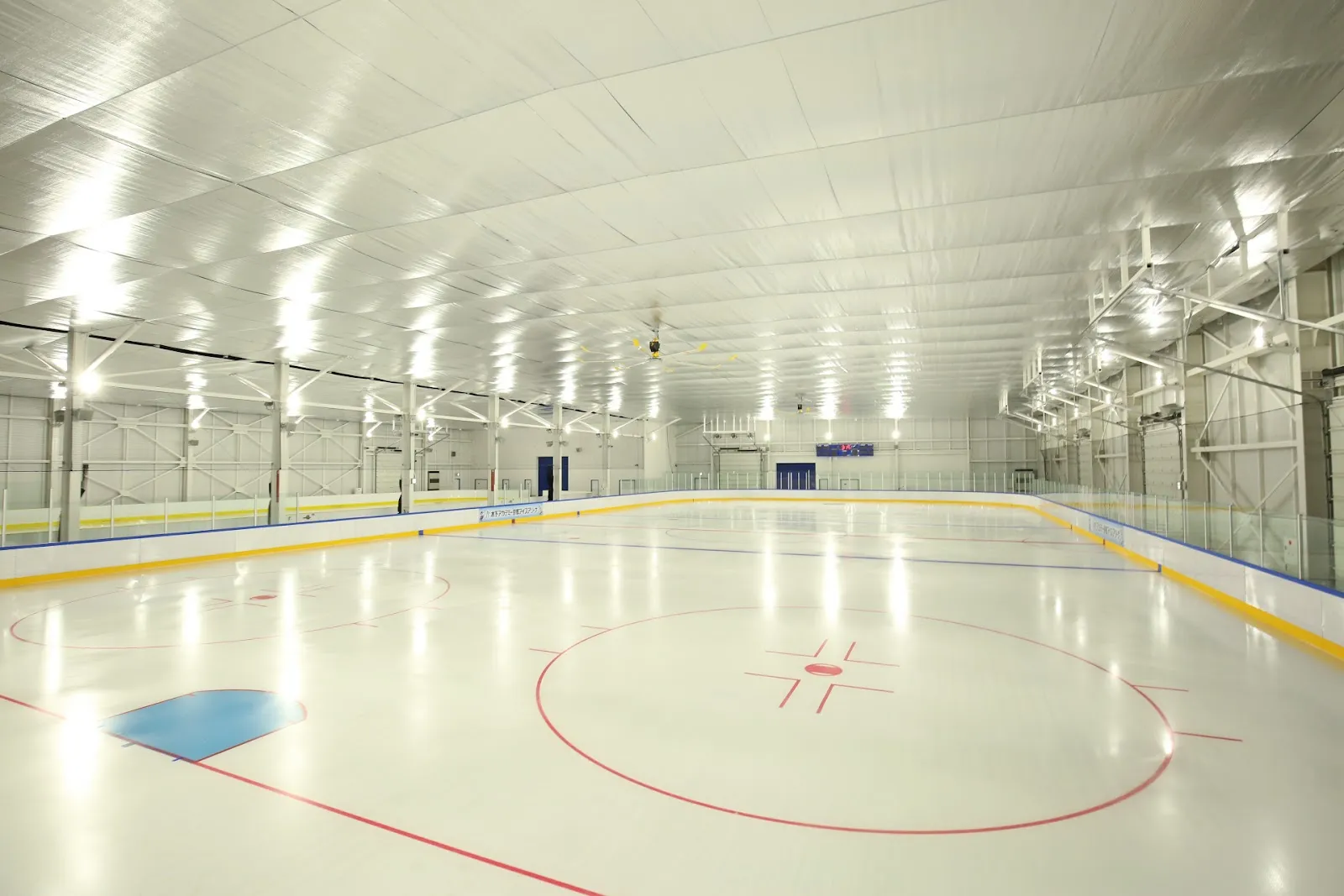 The empty main rink of the Kinoshita Academy Kyoto Ice Arena with hockey markings and a glass-topped boards — Kinoshita Academy Kyoto Ice Arena