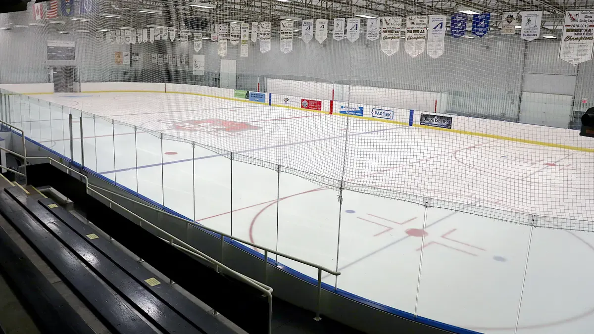 Kinplex Arena 1 seen over the glass from the seats, with championship banners hanging from the roof. — Kinplex