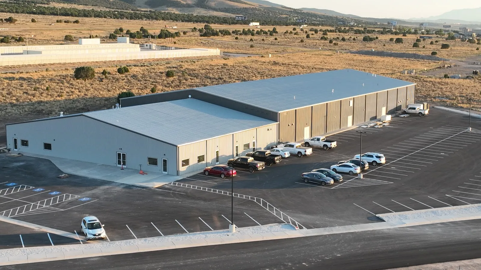 KJ's Ice Barn in Enoch seen from above, a long metal-clad building with its car park — KJ's Ice Barn