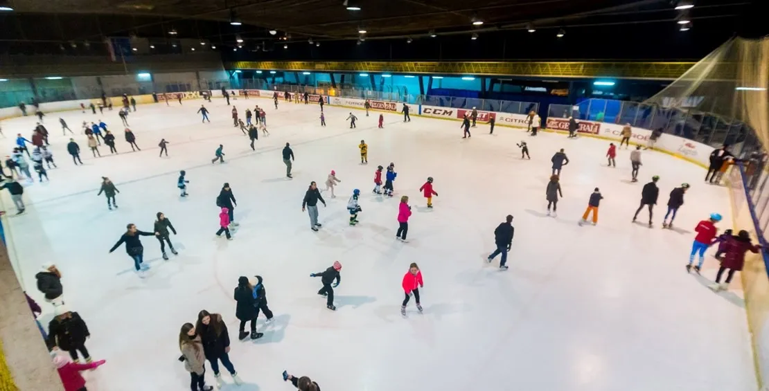 A busy public session on the Velesajam rink in Zagreb, skaters spread across the whole ice from above. — Klizalište Velesajam