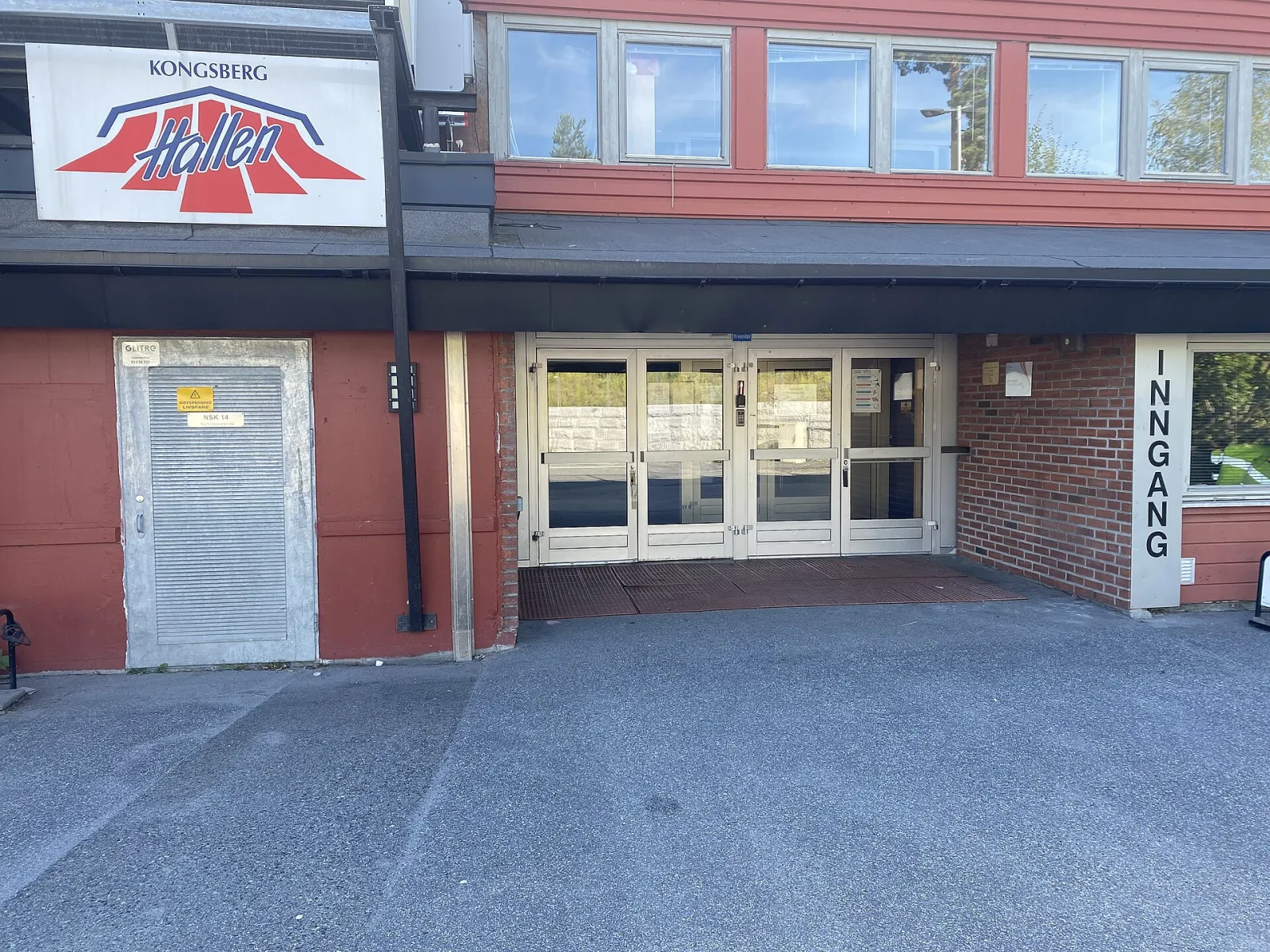 The entrance of Kongsberghallen with the hall's logo above the doors and the word Inngang beside them. — Kongsberghallen
