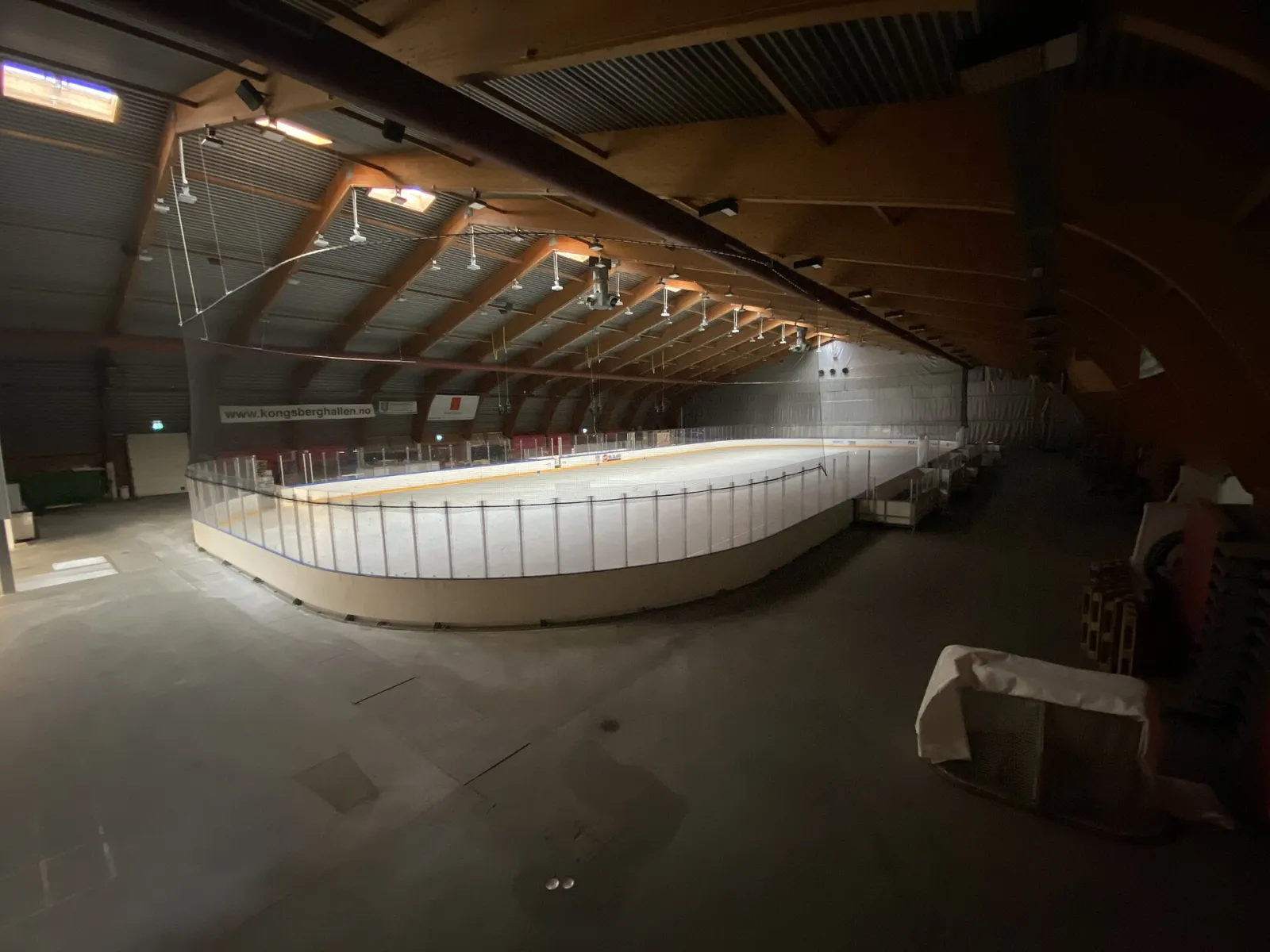 The ice rink inside Kongsberghallen seen from the stands, with the boards and the empty ice in the hall. — Kongsberghallen