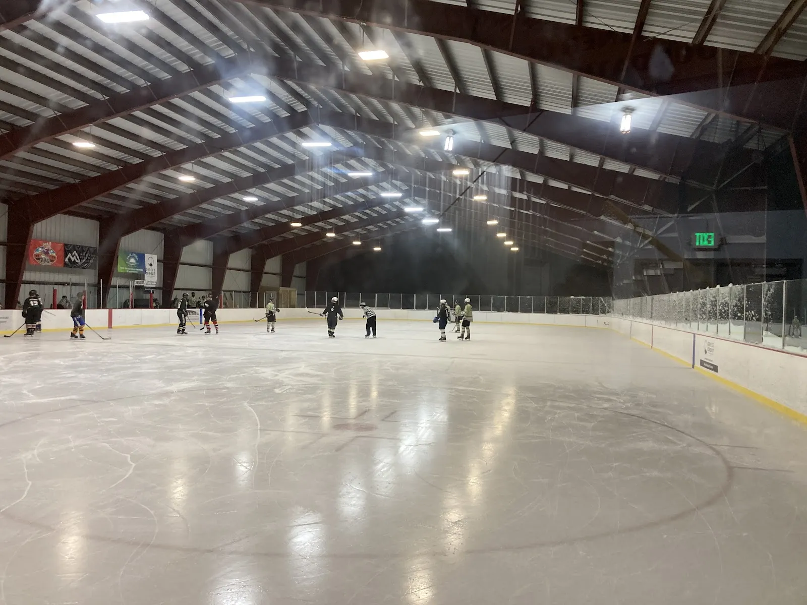 The ice sheet of the Teton Valley Foundation's Kotler Arena with skaters in the distance — Kotler Ice Arena