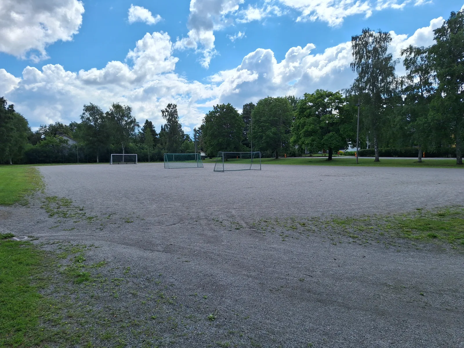 The Kuhilaspuiston field in summer, a ball field with a gravel (stone-dust) surface with goals; the City of Turku freezes its fields into skating fields in winter. — Kuhilaspuiston luistelukenttä