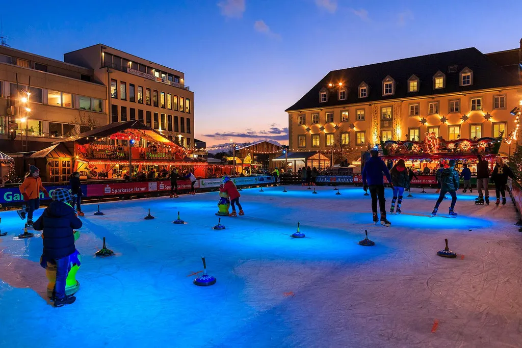 The Hamm Weihnachtsmarkt Kunsteisbahn lit blue in the evening. — Kunsteisbahn Weihnachtsmarkt Hamm