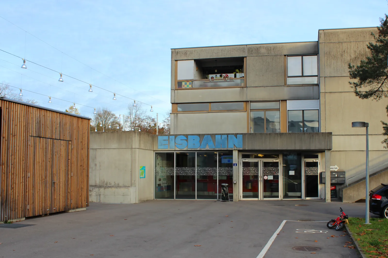 Das Eingangsgebäude der Kunsteisbahn Weyermannshaus in Bern mit dem blauen Schriftzug Eisbahn über den Türen – Kunsteisbahn Weyermannshaus