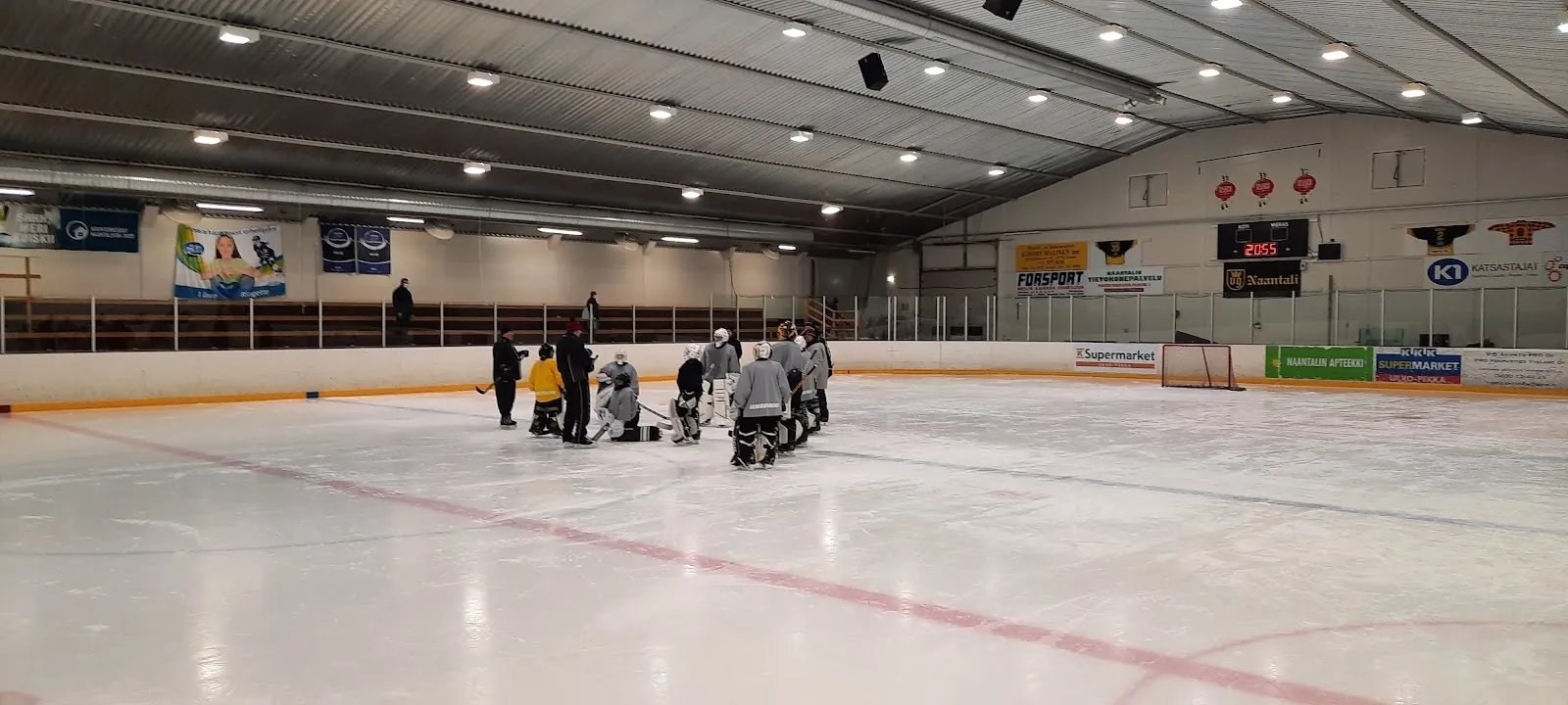 A wide view across the ice of Kuparivuoren jäähalli in Naantali, with the boards and the hall wall behind. — Kuparivuorihalli