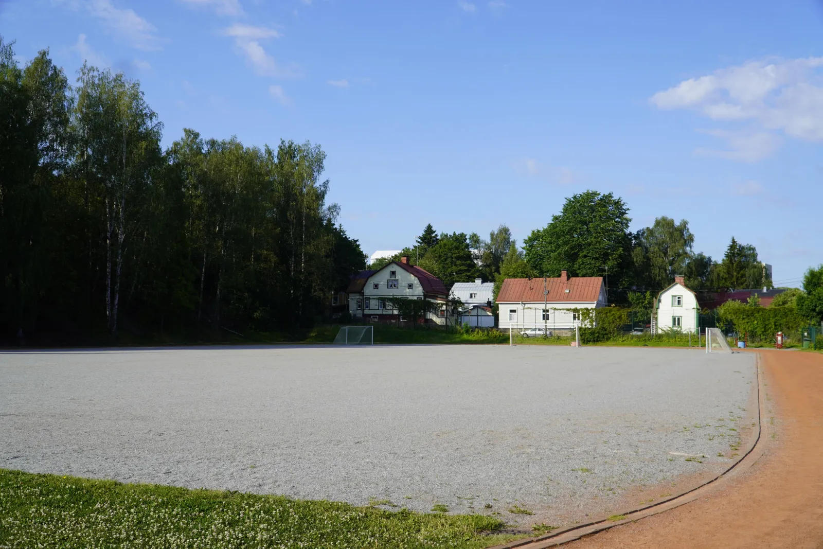 The Kuuvuoren field in summer, a ball field with a gravel (stone-dust) surface with goals; the City of Turku freezes its fields into skating fields in winter. — Kuuvuoren luistelukenttä