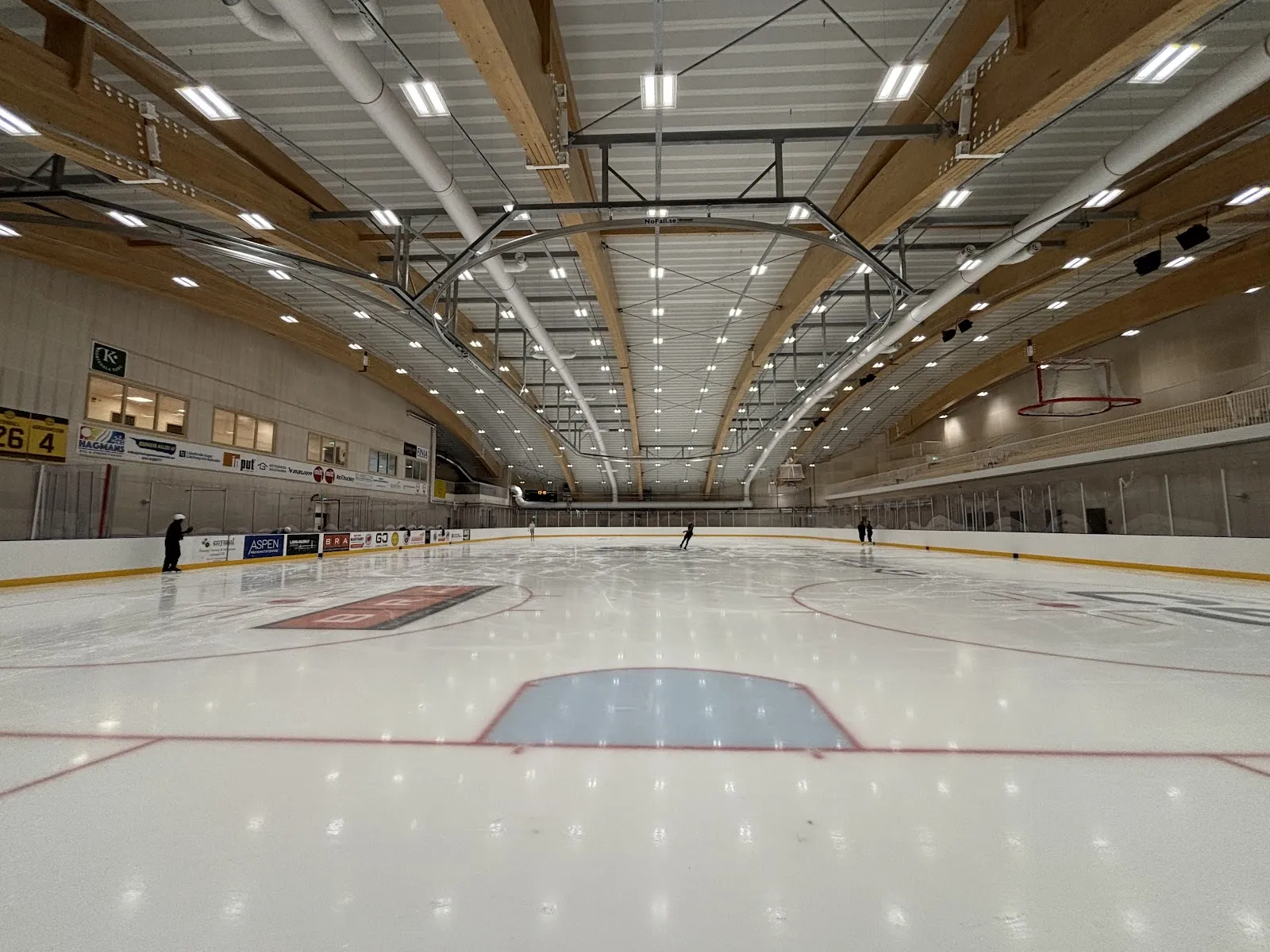 Empty ice of Kvibergs Parks is- och sporthall under its timber-framed roof — Kvibergs Parks is- och sporthall