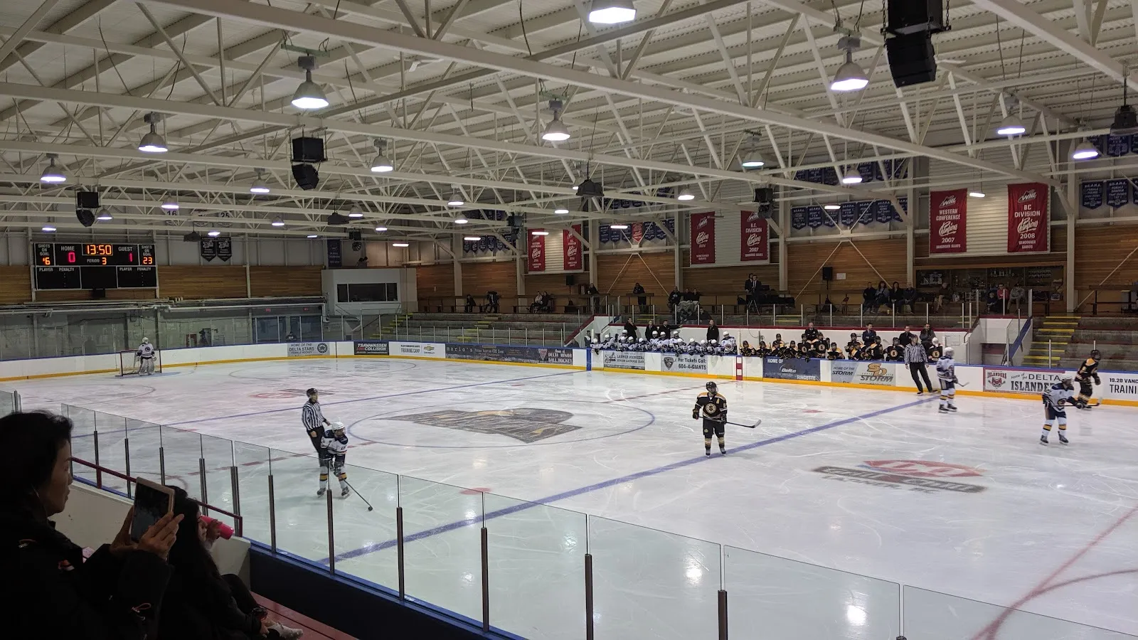 Ladner Leisure Centre arena: a hockey game on the ice with the stands and scoreboard — Ladner Leisure Centre