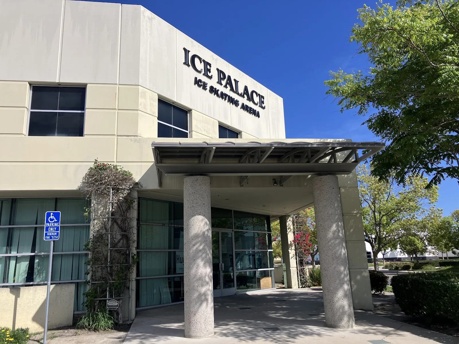 The entrance canopy on round columns below the ICE PALACE Ice Skating Arena lettering on the building's corner. — Lake Forest Ice Palace