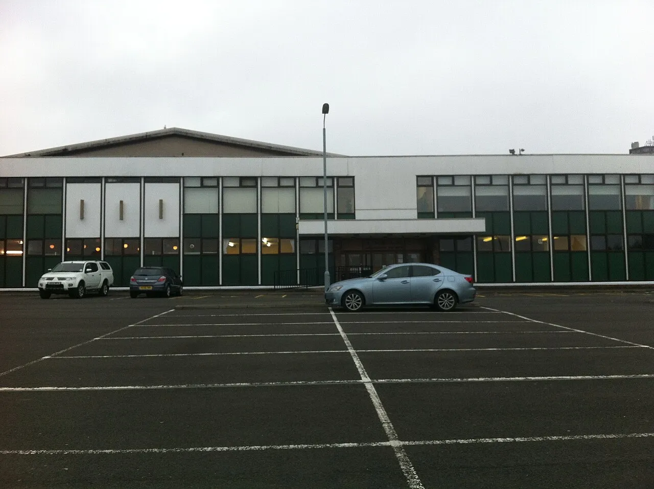The Hamilton ice rink building seen across its car park — Lanarkshire Ice Rink (Hamilton)