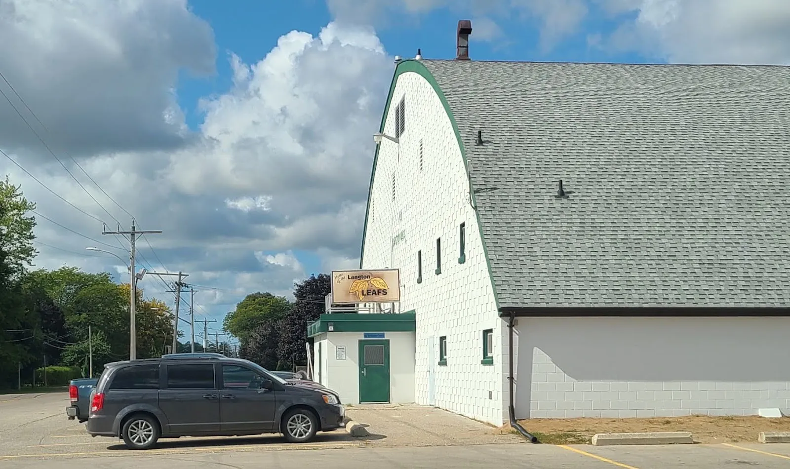 The white arched-roof Langton Arena on Albert Street in Langton, with the Langton Leafs sign over its side door — Langton Arena