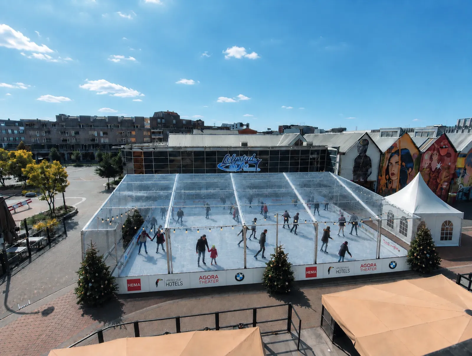 Aerial view of the Lelystad on Ice rink in the square at De Waag, with the white rink in the middle and tents and low buildings around it. — Lelystad On Ice