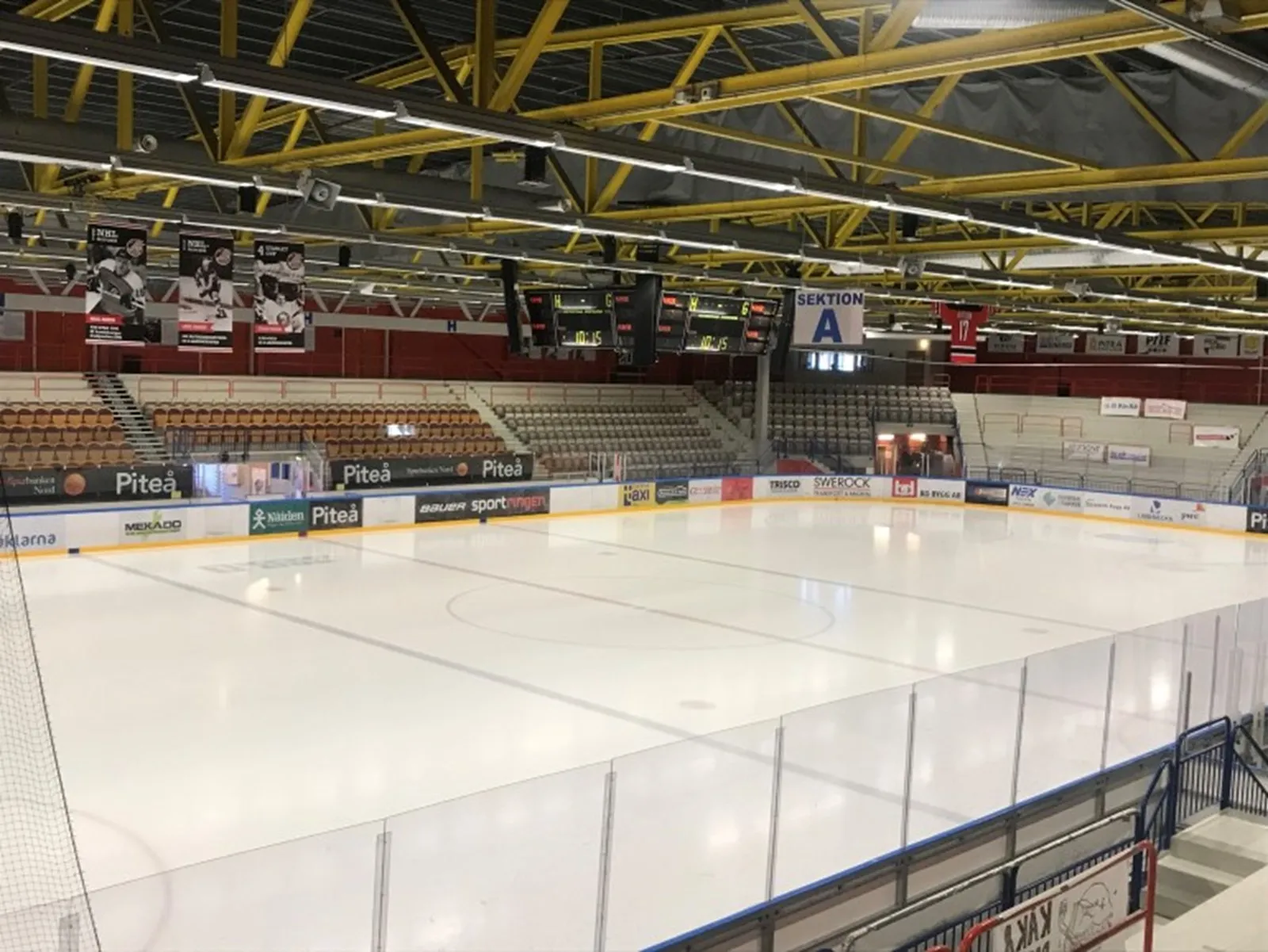 Isen i LF Arena i Piteå med läktare bakom. – LF Arena