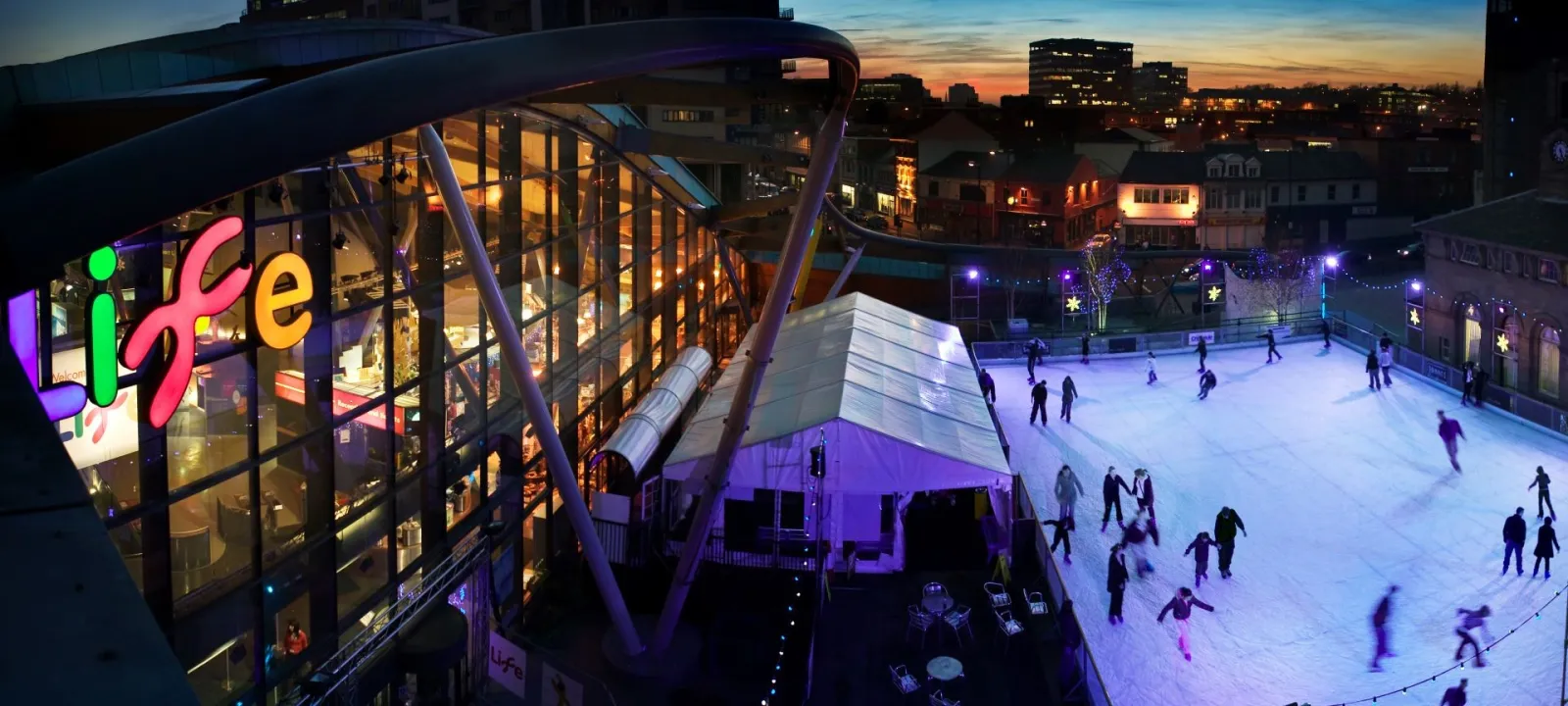 The open-air rink on Times Square beside the Life Science Centre building at dusk (the centre's photo, published on the Get into Newcastle page) — Life Science Centre Ice Rink (Newcastle)
