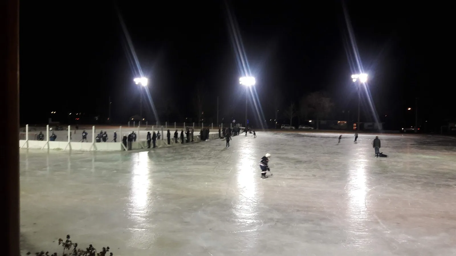 Patinadores en la pista al aire libre iluminada de Linden Hills Park, Minneapolis, de noche (foto del listado de Google Maps) — Linden Hills Park Outdoor Rink