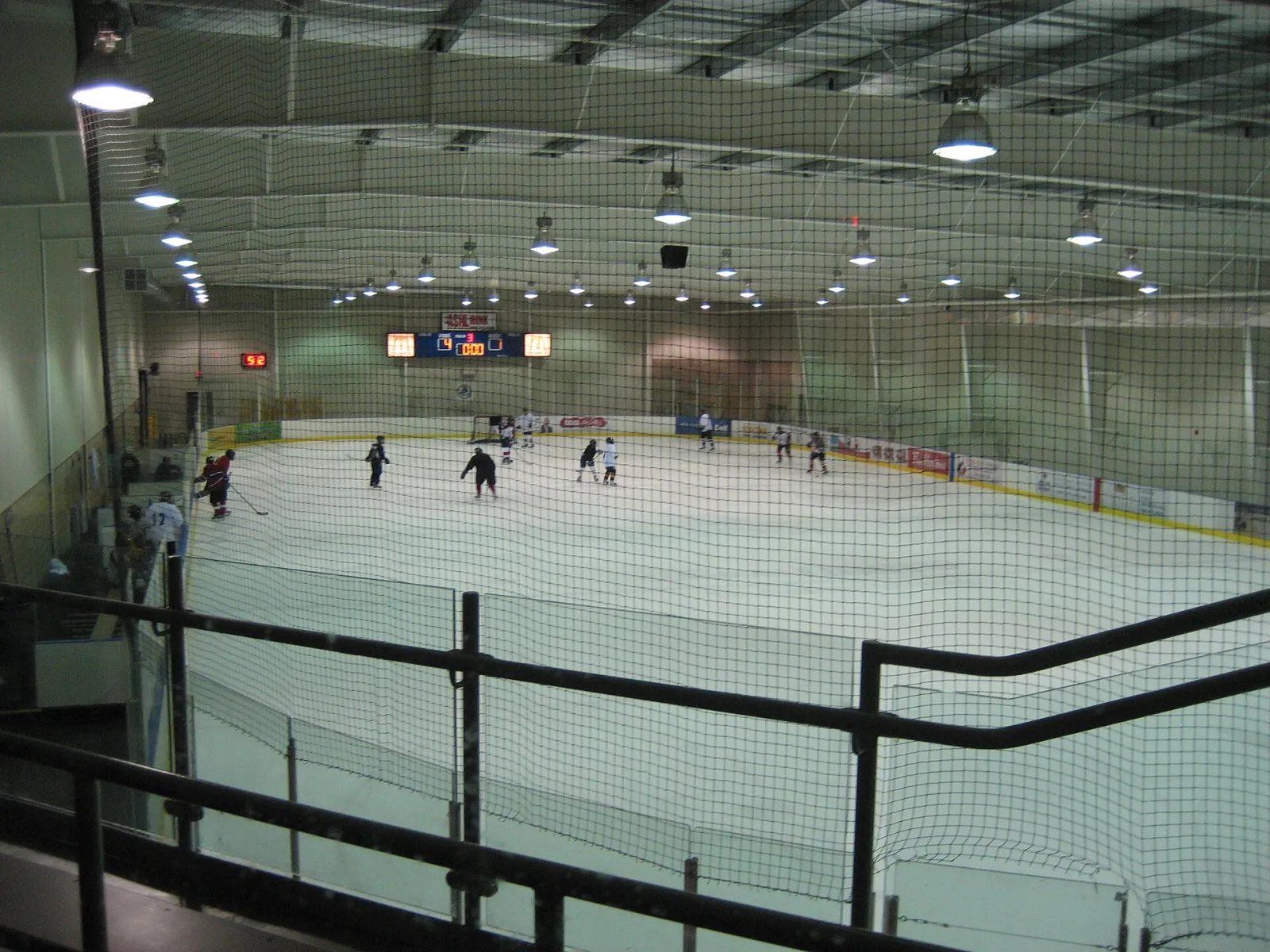 Una de las cuatro pistas de tamaño NHL vista desde el barandal superior, con un partido en curso. — LIUNA 4 Ice Centre