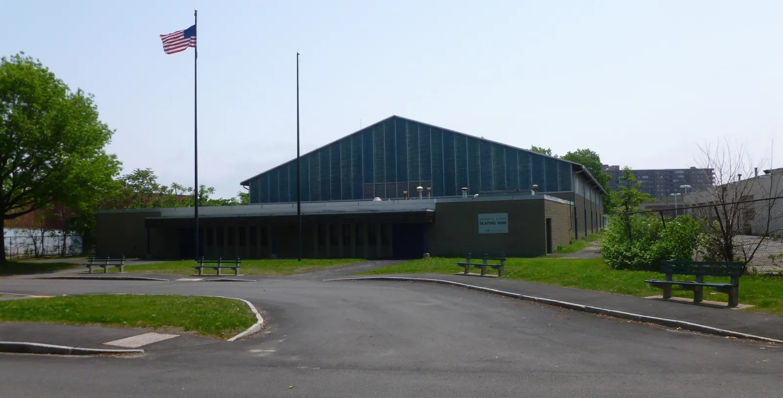 The LoConte Skating Rink on Locust Street: the tall gabled rink hall behind the low entrance wing with its sign, flagpoles and benches — LoConte Memorial Rink