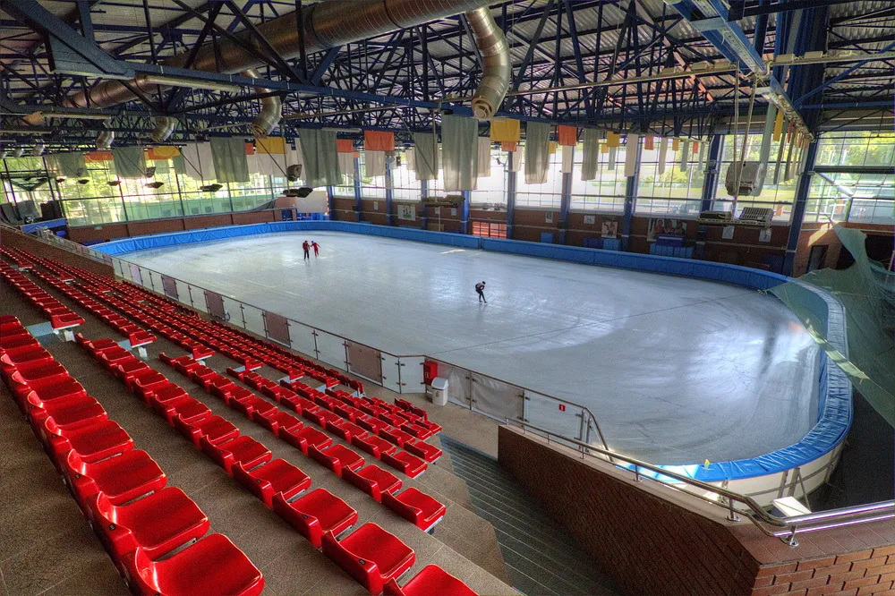 The ice sheet and red stands of the BOSiR rink hall in Białystok — Lodowisko BOSiR (Zwierzyniec)