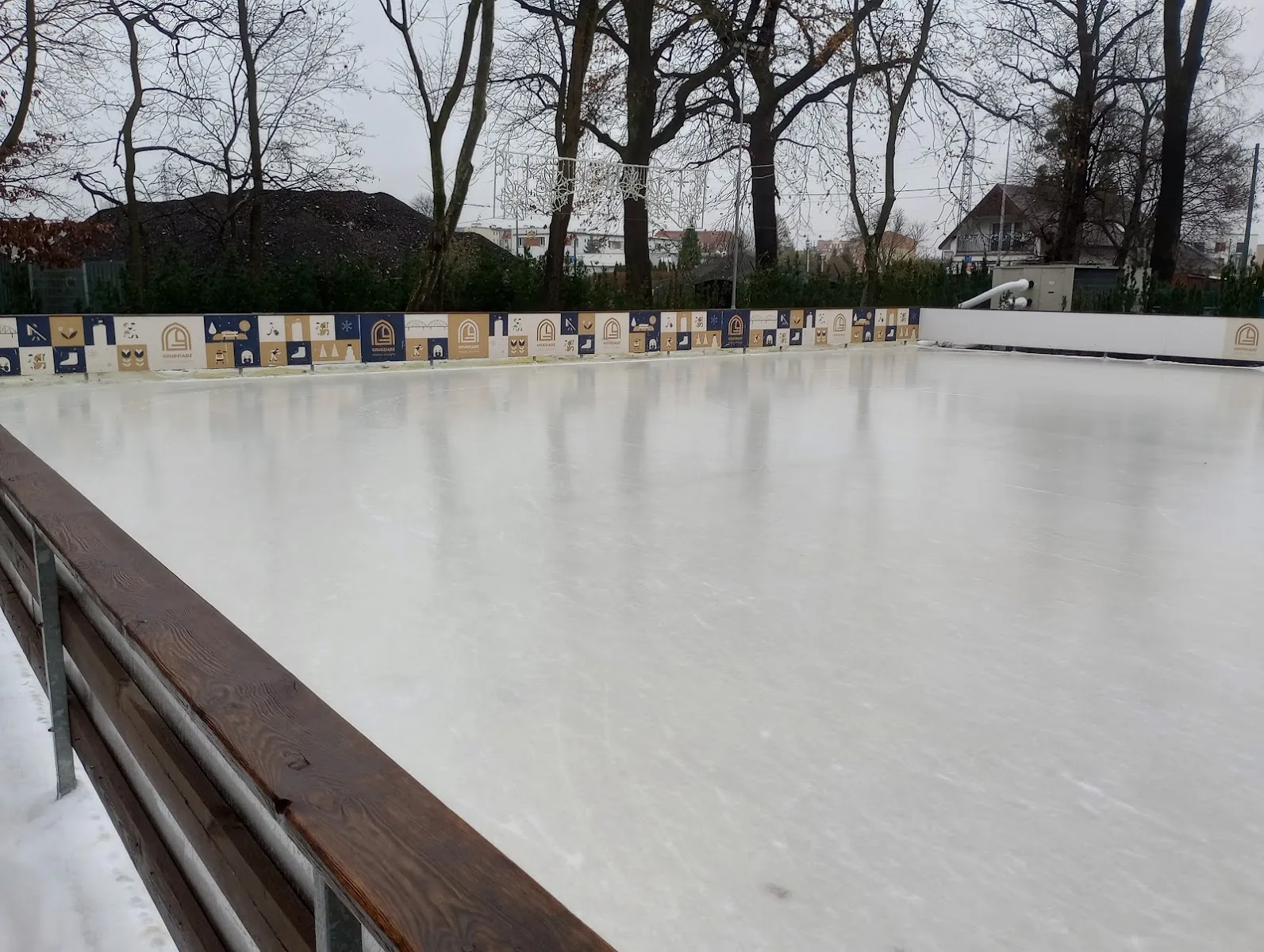 The empty seasonal ice rink in the city park with its wooden rail — Lodowisko Sezonowe w Parku Miejskim Grudziądz