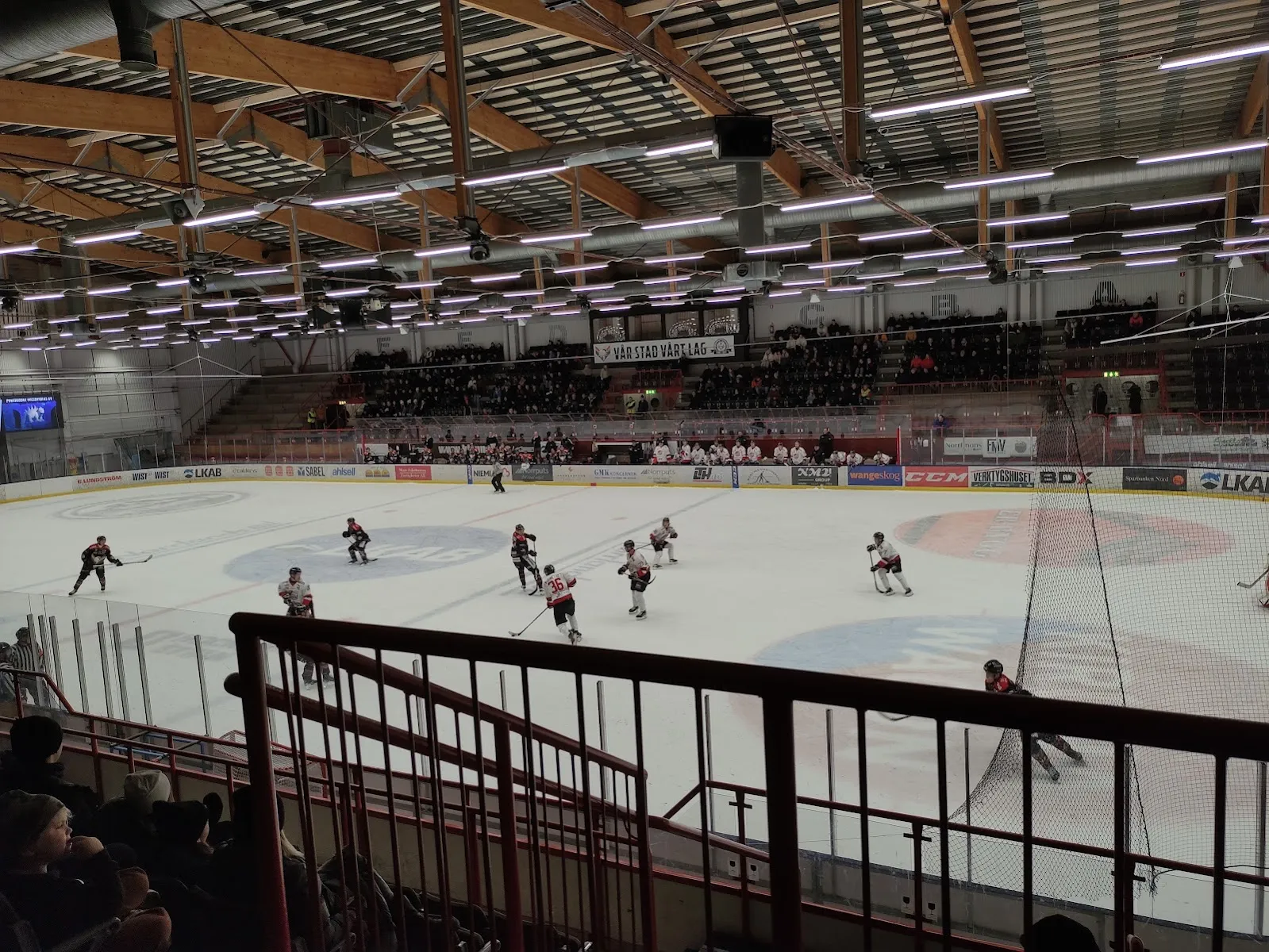 A game on the ice sheet of Lombiahallen in Kiruna, seen from the stand with the timber roof above – Lombia ishall (Kiruna)
