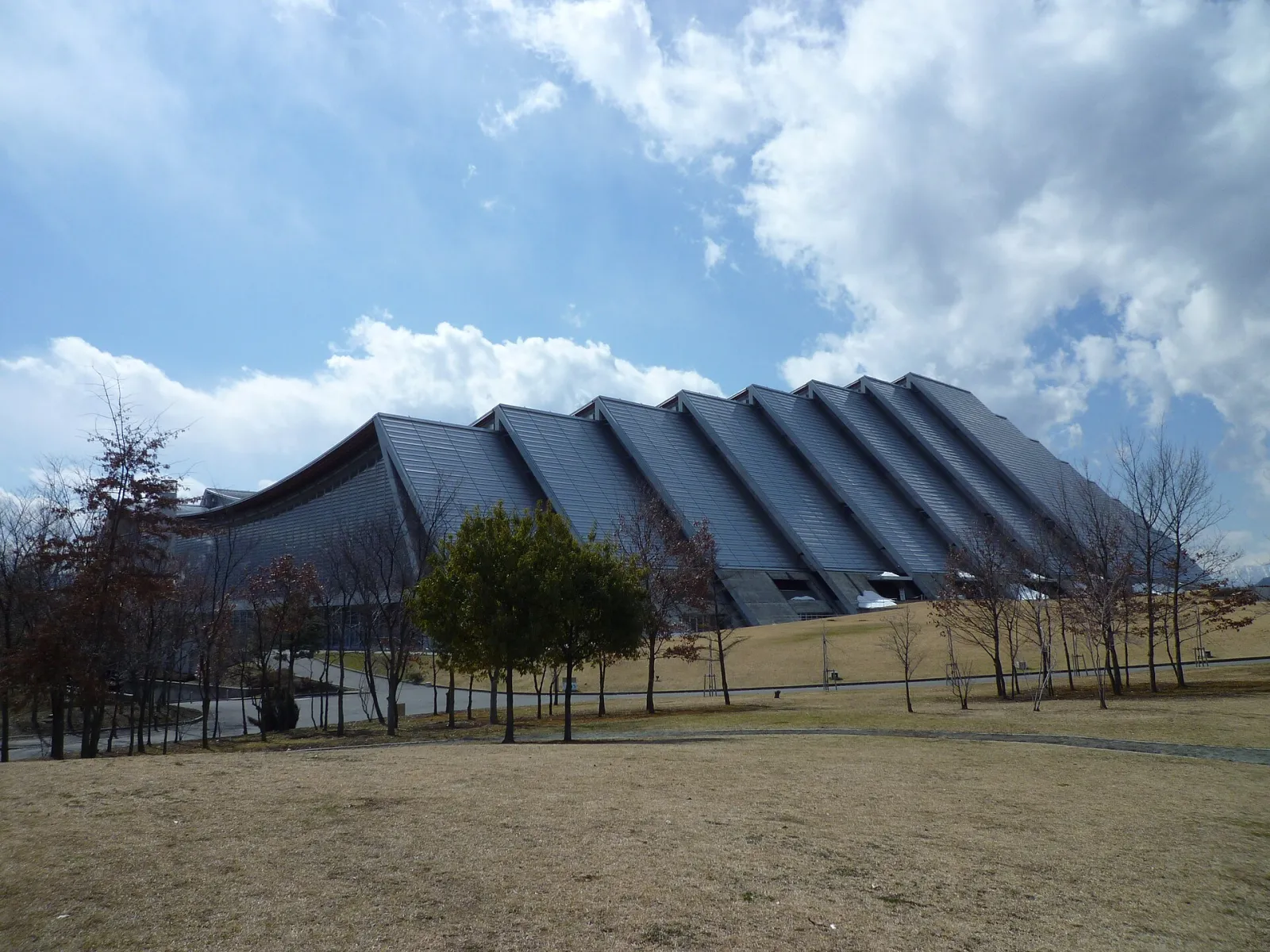 The ridged roof of the Nagano Olympic Memorial Arena (M-Wave) seen across the grounds — M-Wave (Nagano Olympic Memorial Arena)