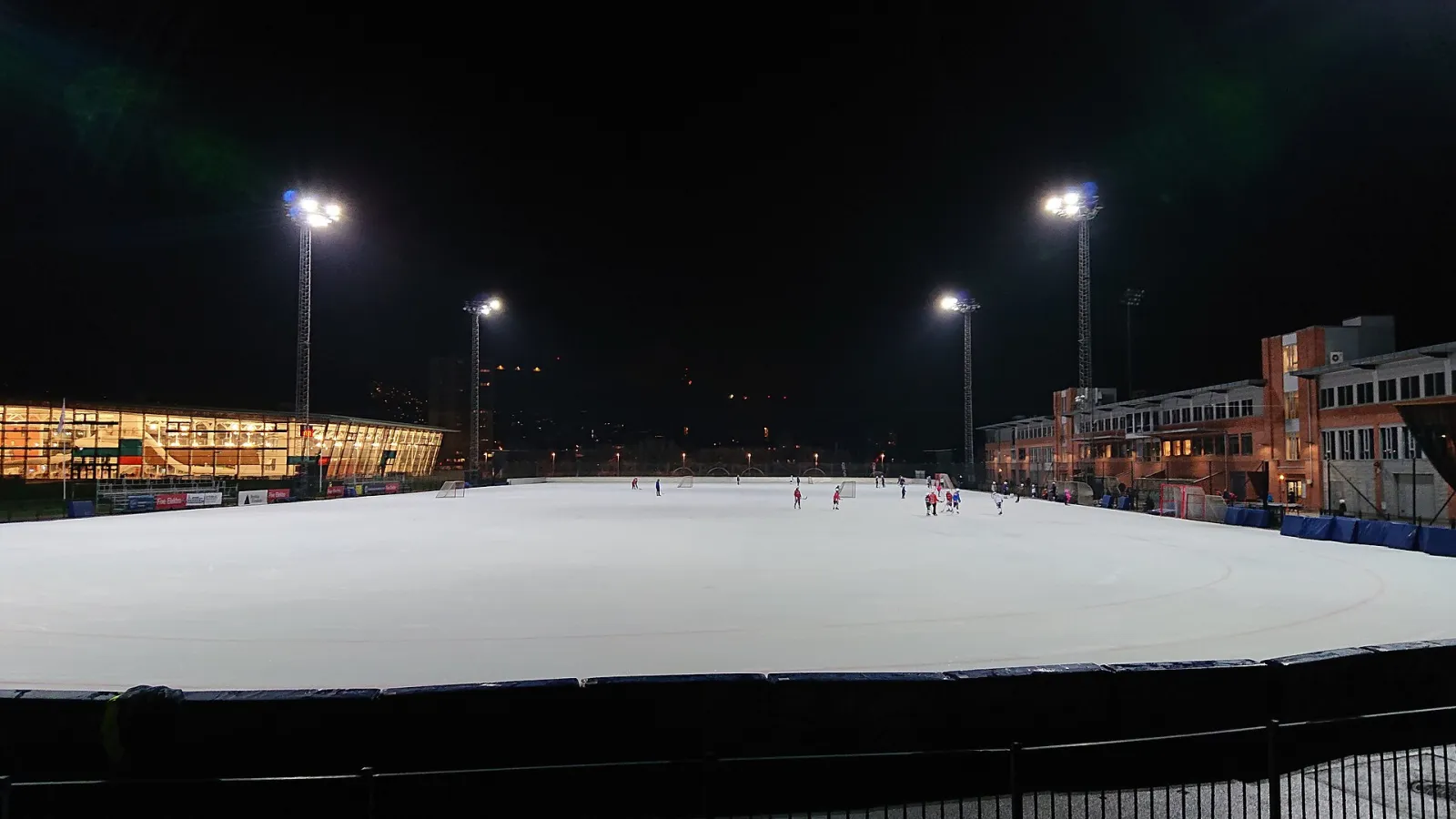 The Marienlyst kunstisbane at night, with bandy players on the ice — Marienlyst kunstisbane
