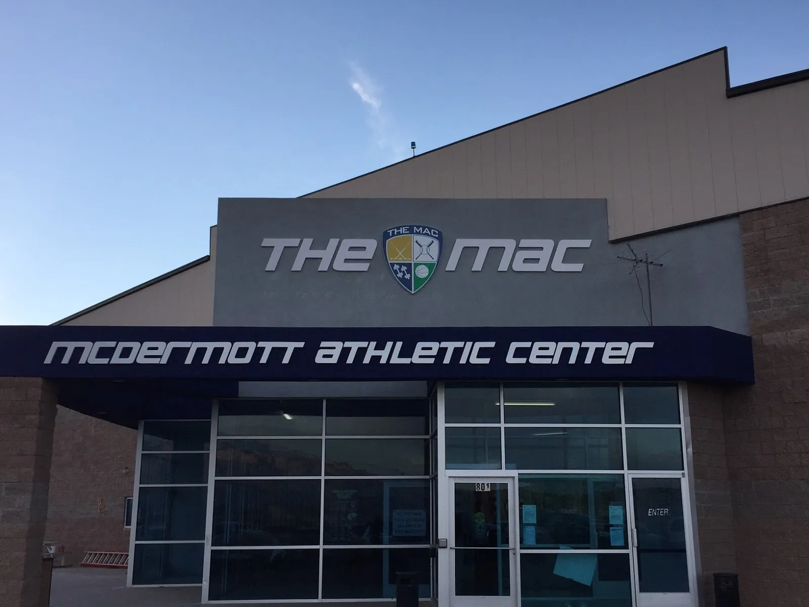 The entrance of The MAC, with the McDermott Athletic Center sign over the glass doors. — McDermott Athletic Center