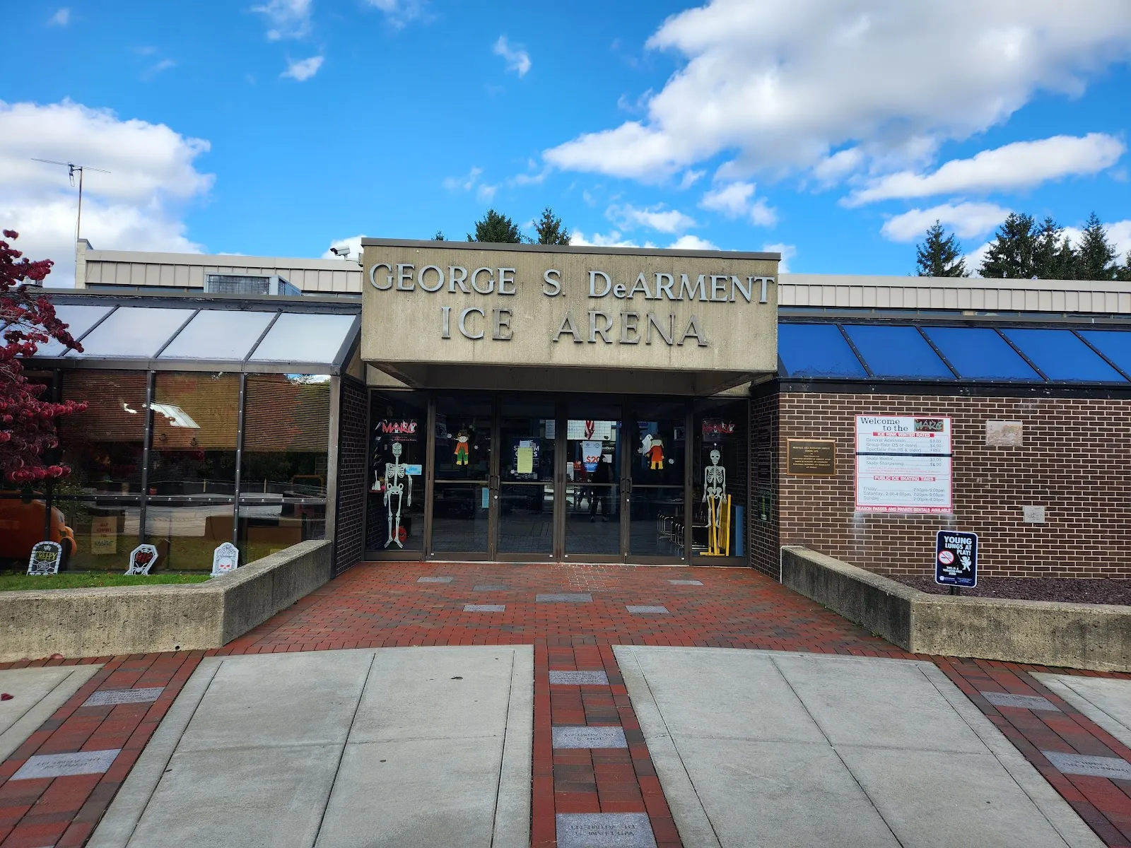 The brick entrance of the George S. DeArment Ice Arena at the Meadville Area Recreation Complex, with the name over the glass doors and a paved walk up to them — Meadville Area Recreation Complex
