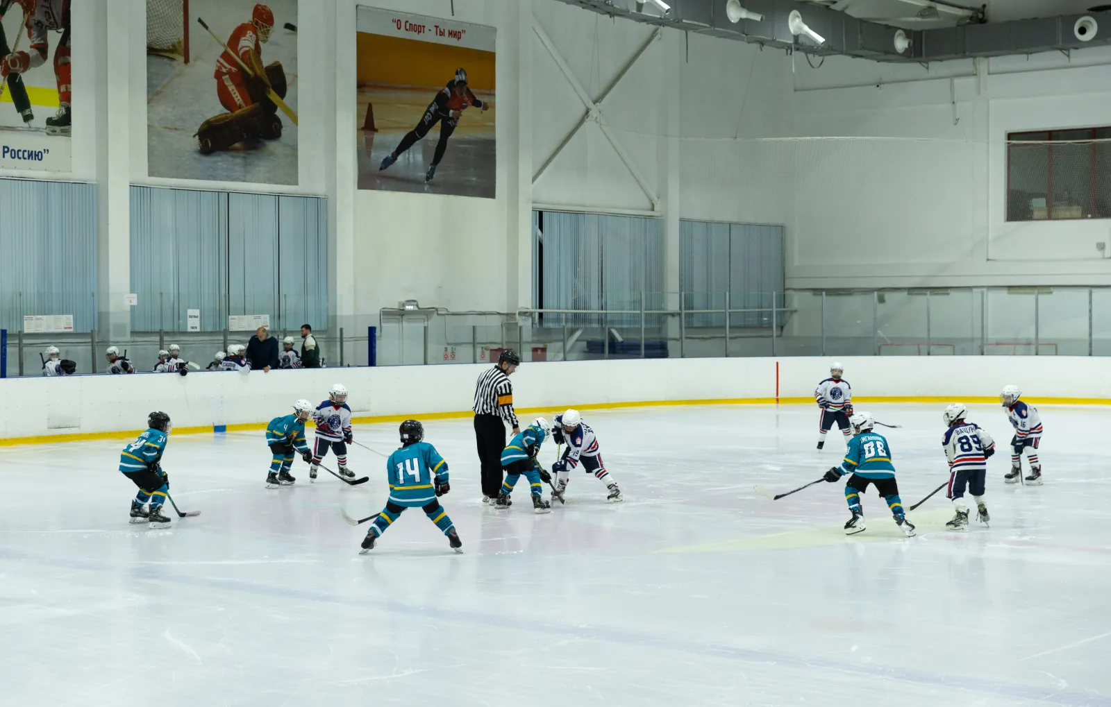 The ice hall of the Medved ice complex in Ovoshchnoy, with a children's hockey session in the distance, from the operator's own gallery — Medved Ice Complex