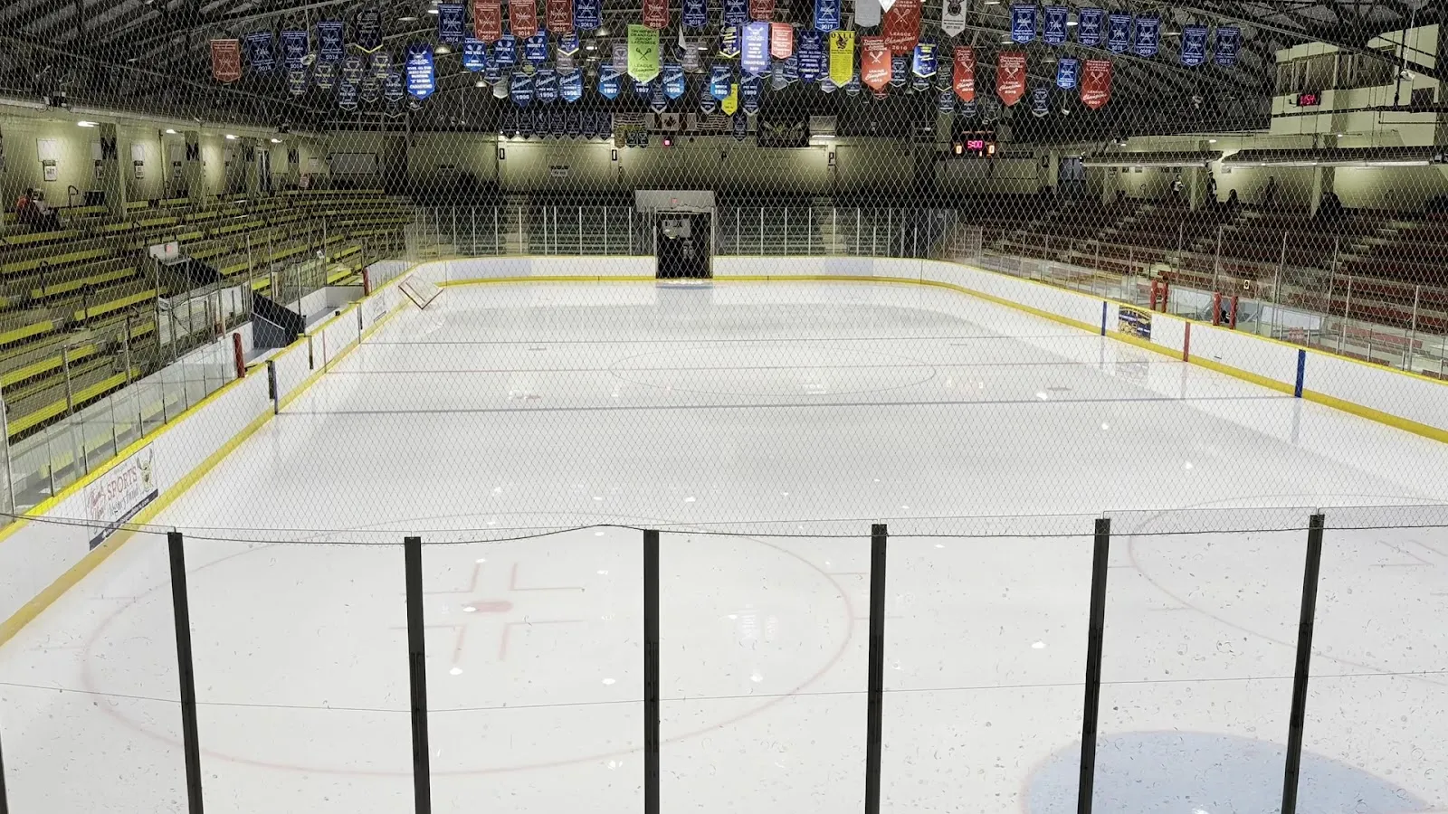 Memorial Arena ice and stands under the banners, seen from the end of the rink — Memorial Arena