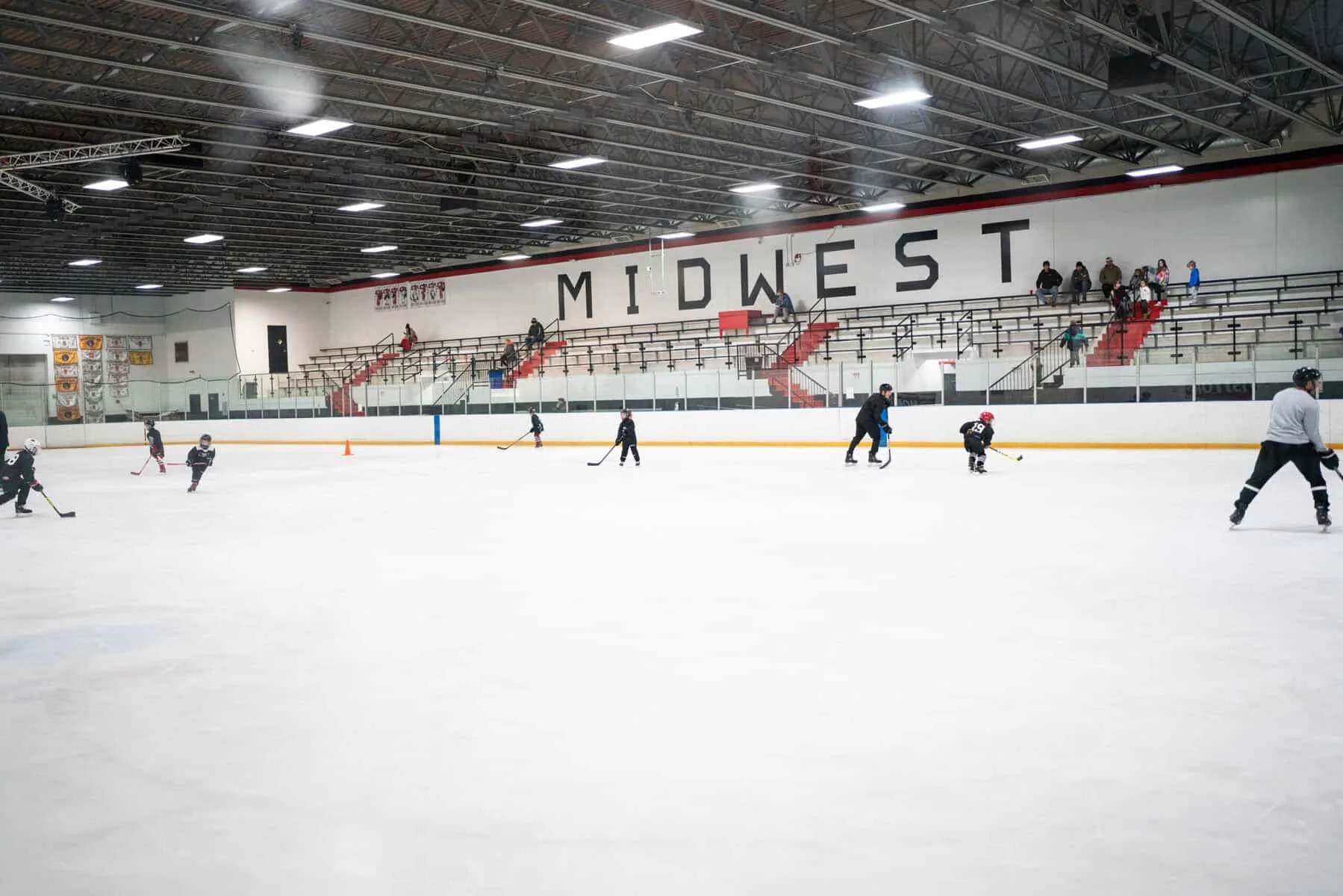 Todo el ancho de la pista desde el nivel del hielo, con gradas rojas y blancas al fondo — Midwest Training and Ice Center (Dyer)