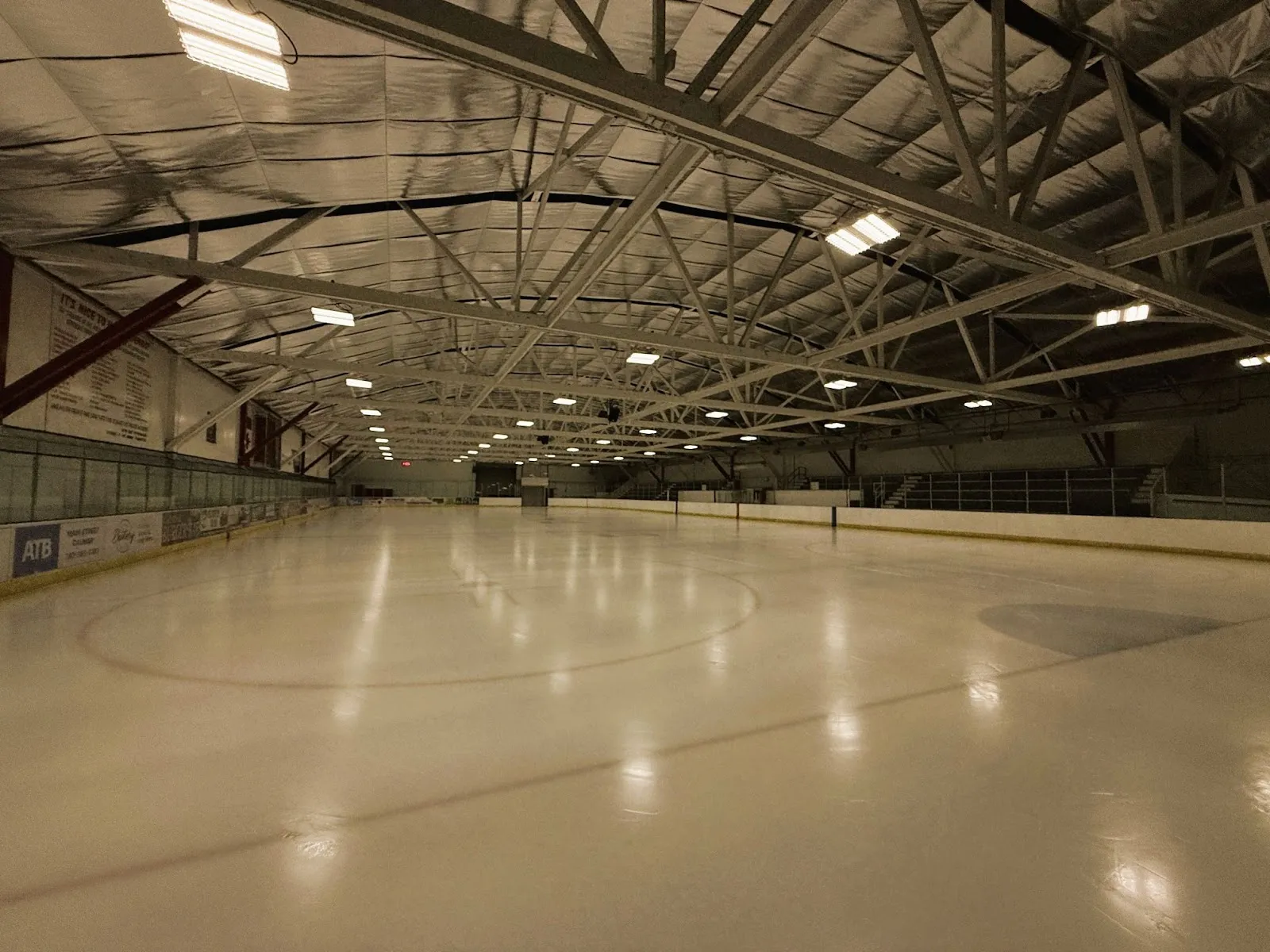 The empty sheet under the arched steel roof, looking down the ice from centre. — Mike Karbonik Arena