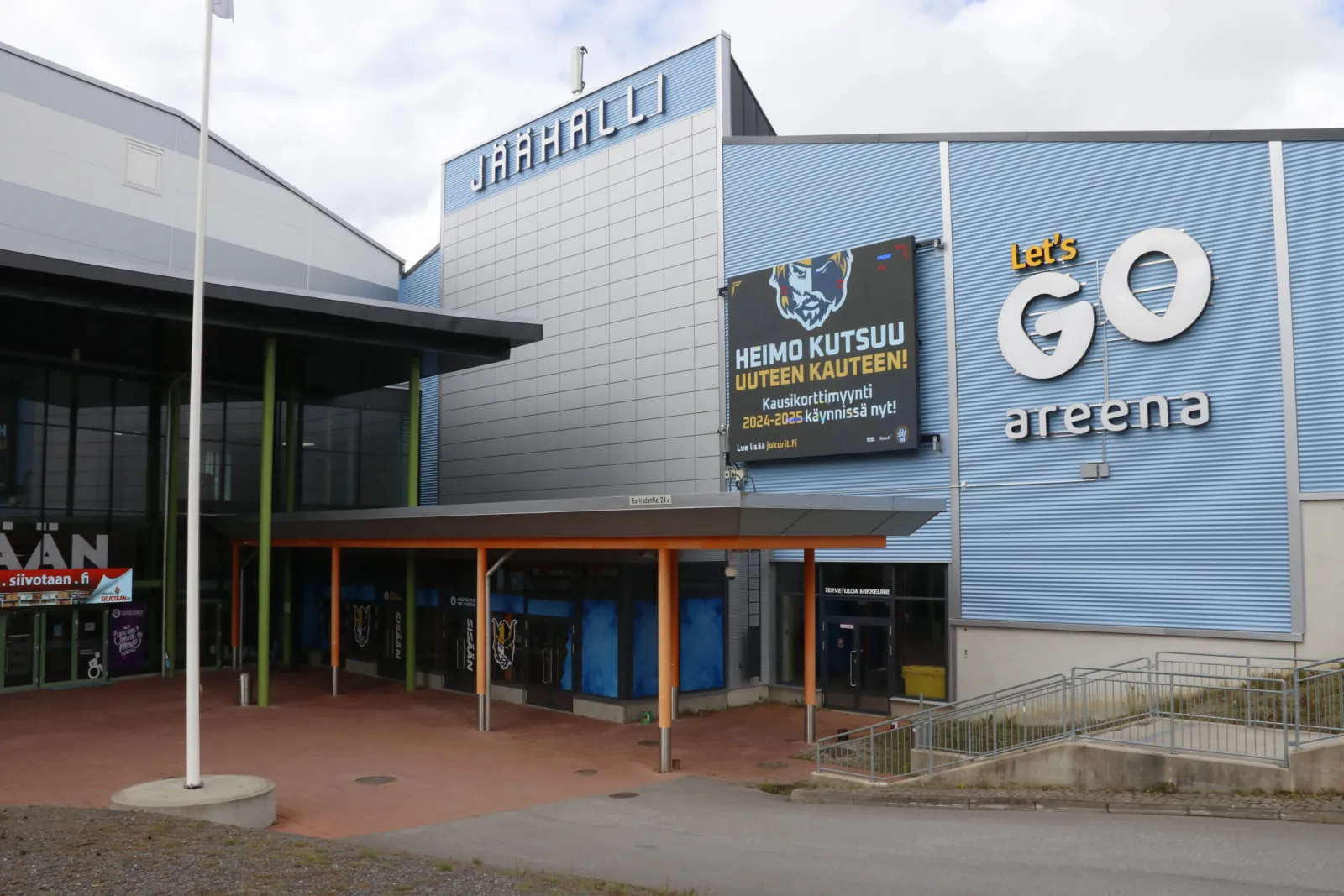 The entrance front of Mikkelin jäähalli with the JÄÄHALLI sign and the Let's go areena logo on its blue cladding. — Mikkelin jäähalli