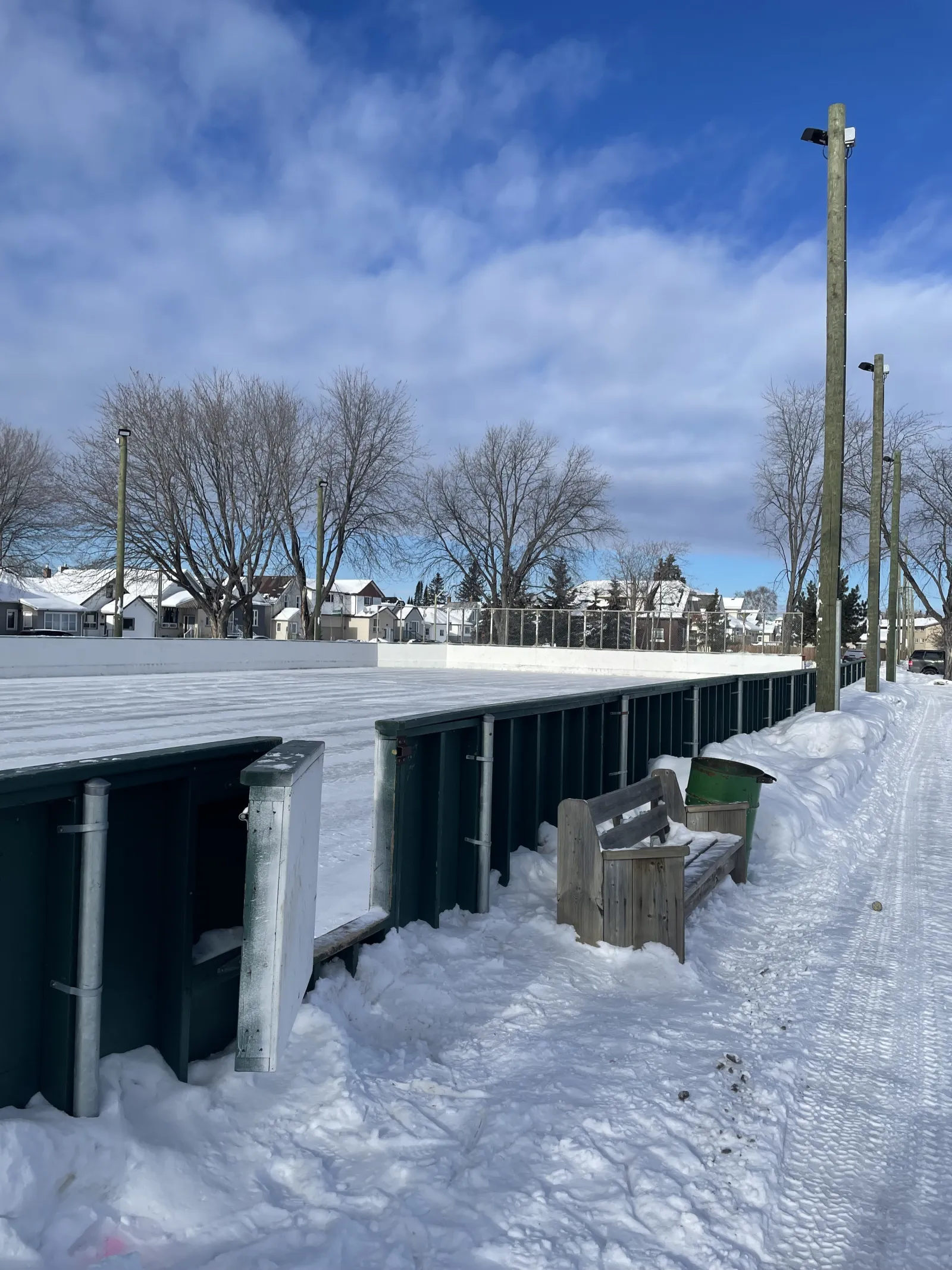 Vallas, una banca y un bote de basura a lo largo de la pista de Minnesota Park — Minnesota Park Outdoor Rinks