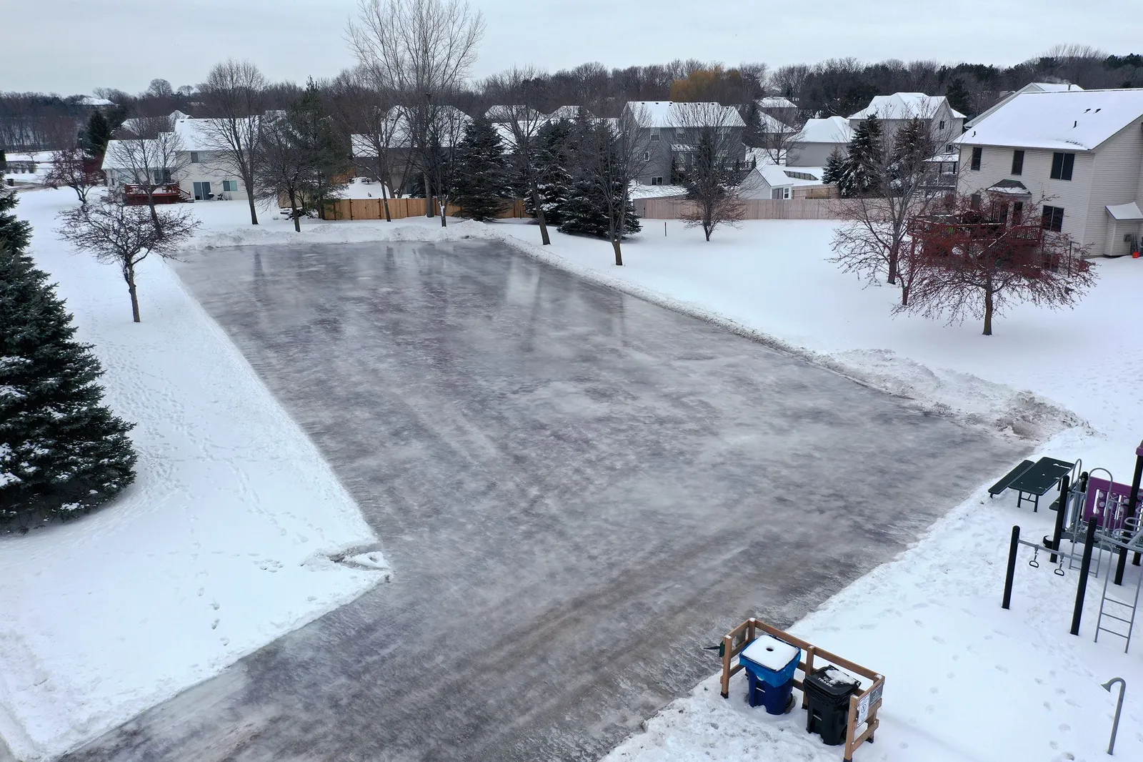 The Mississippi Oaks Park outdoor skating rink in Elk River, seen from above with a fresh ice surface in winter. — Mississippi Oaks Park Ice Rink