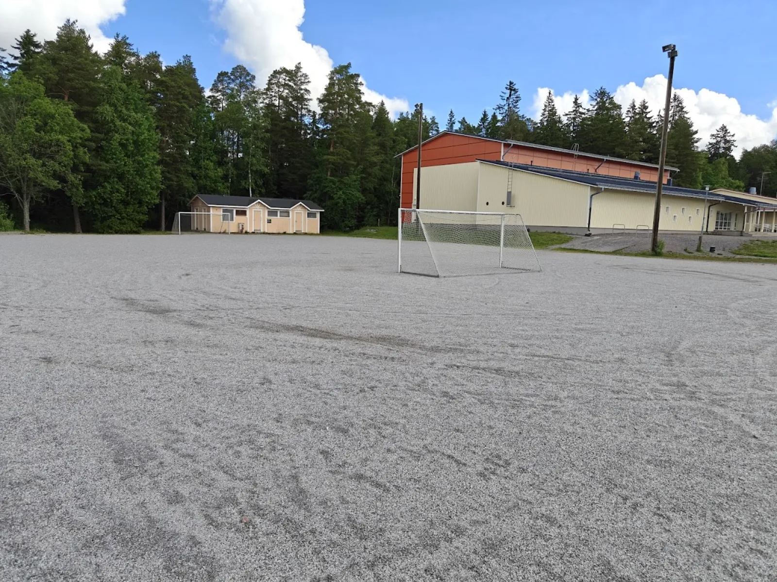 The Moision field in summer, a ball field with a gravel (stone-dust) surface with goals; the City of Turku freezes its fields into skating fields in winter. — Moision luistelukenttä