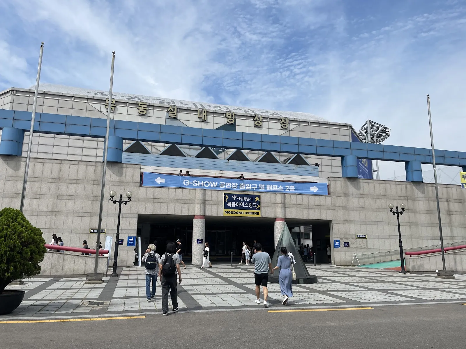The entrance of Mokdong Ice Rink with the hall's name over the doors and the city's rink sign, seen from the forecourt. — Mokdong Ice Rink