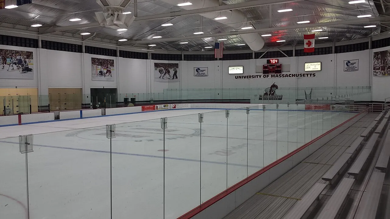 La Mullins Center Community Rink vista a través del cristal, con el nombre de la University of Massachusetts en la pared del fondo. — Mullins Center Community Ice Rink