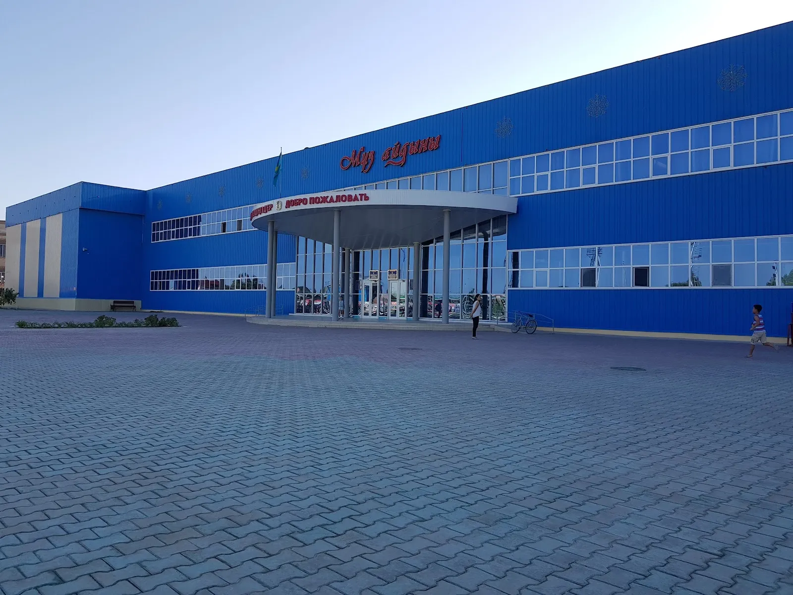 The blue Muz Aidyny sports complex in Kyzylorda with its round entrance canopy and the name above the doors — Muz Aidyny Ice Rink